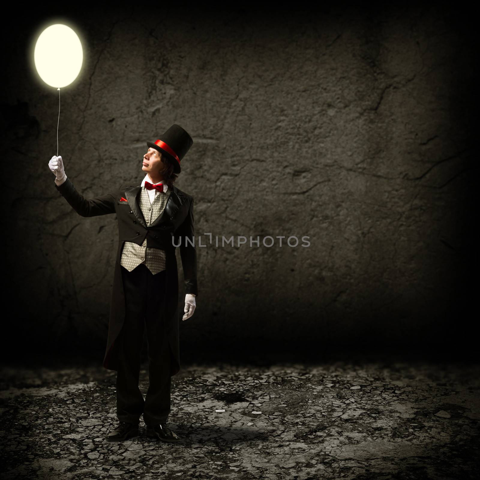 magician in top hat and tie, holding a glowing baloon, and staring at him