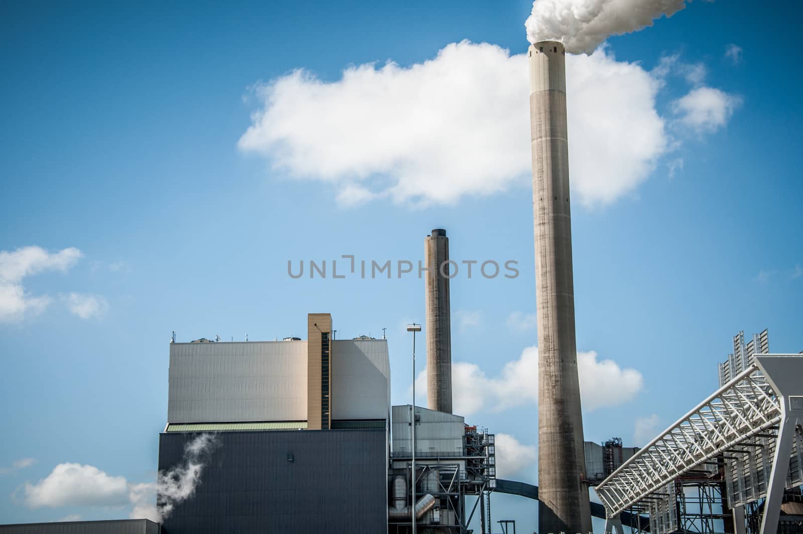 industrial chimney spewing smoke on blue sky