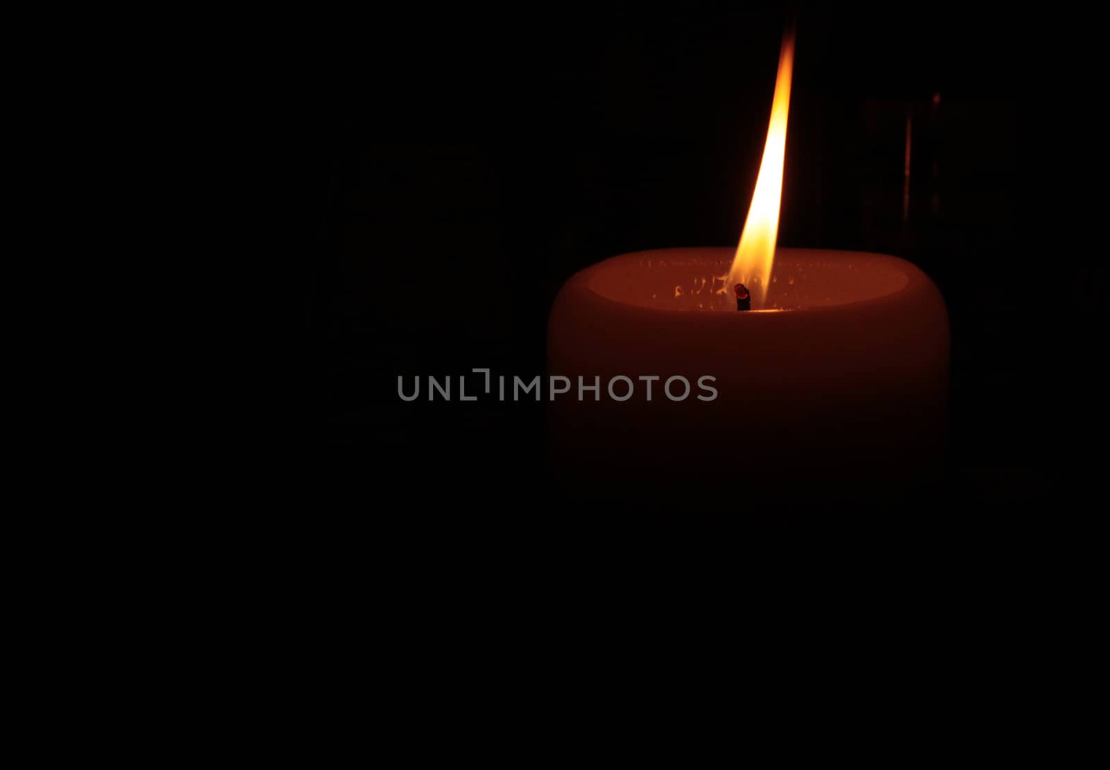 Orange candle burning in the dark