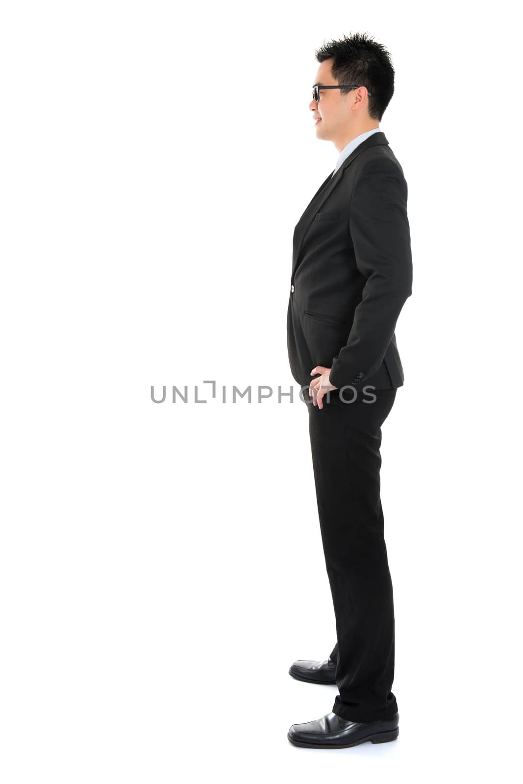Side view full body Asian business man in formal suit standing isolated on white background