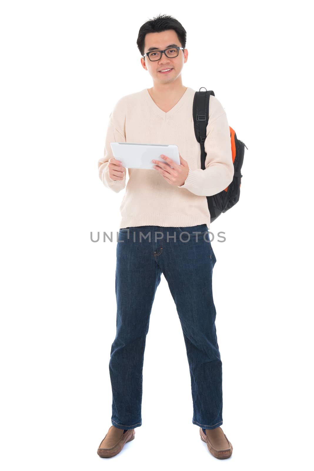 Full body Asian adult student in casual wear  using digital computer tablet pc standing isolated on white background. Asian male model.