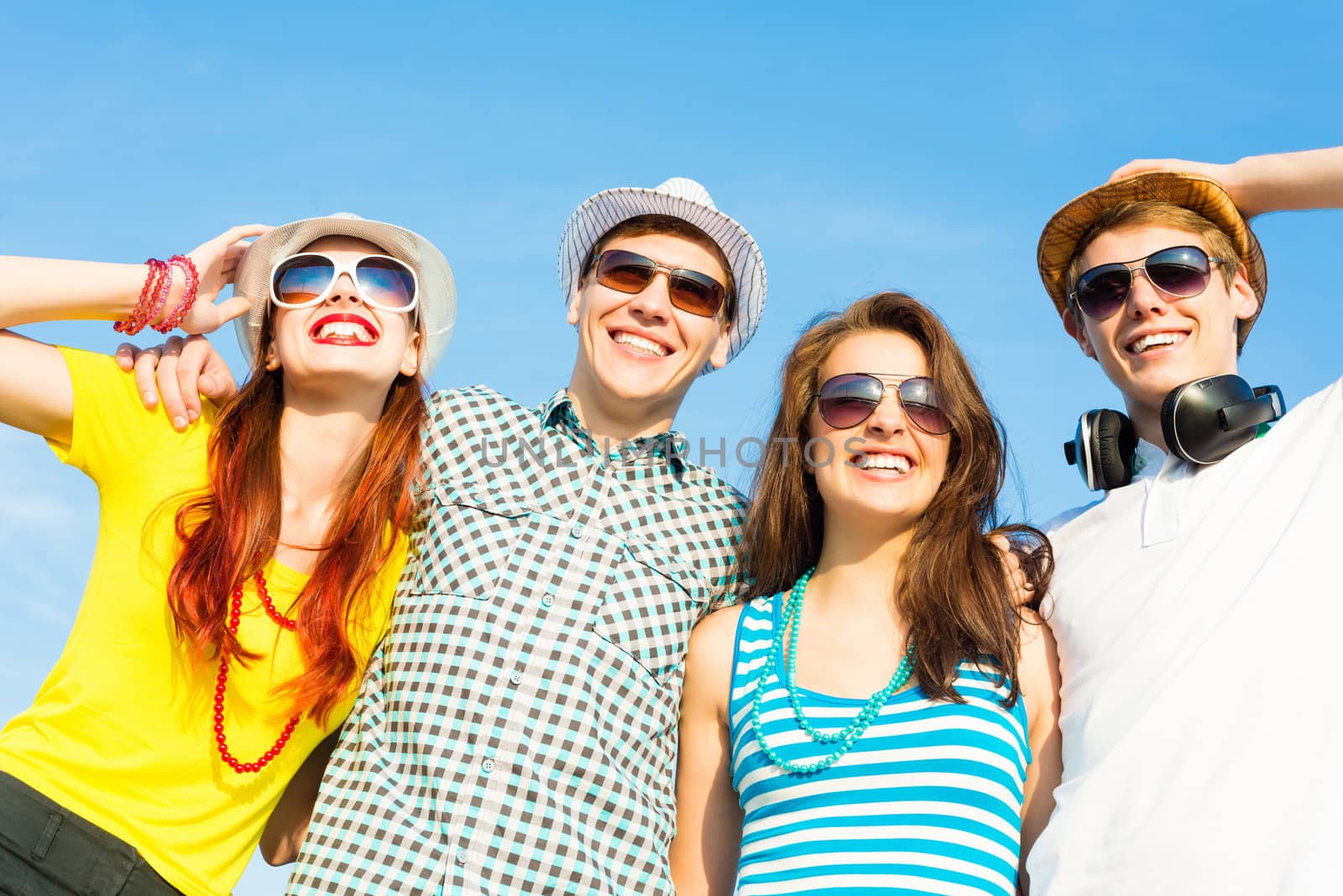 group of young people wearing sunglasses and hats hugging and standing in a row, spending time with friends