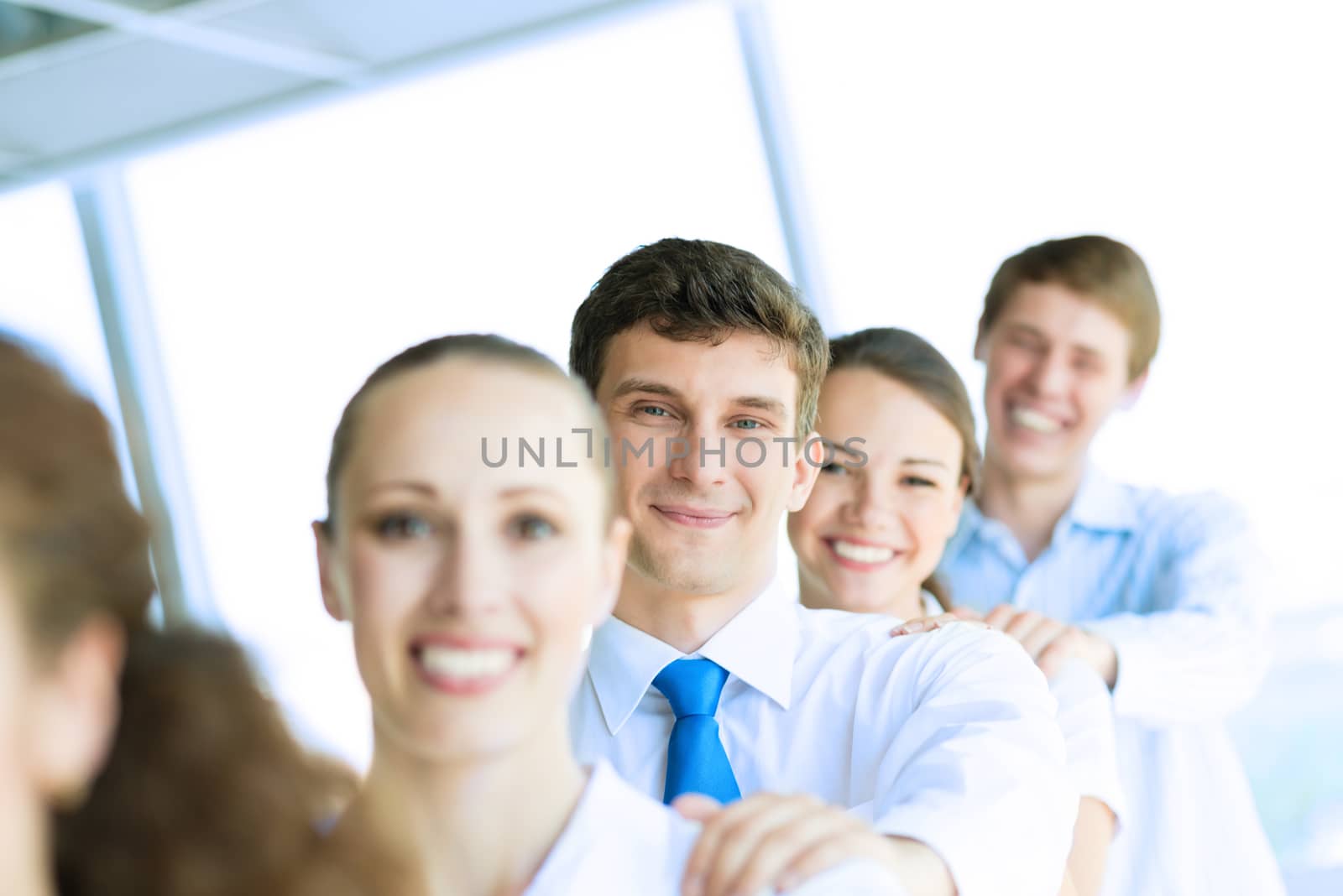 portrait of a young businessman standing in a row with his colleagues, concept of teamwork