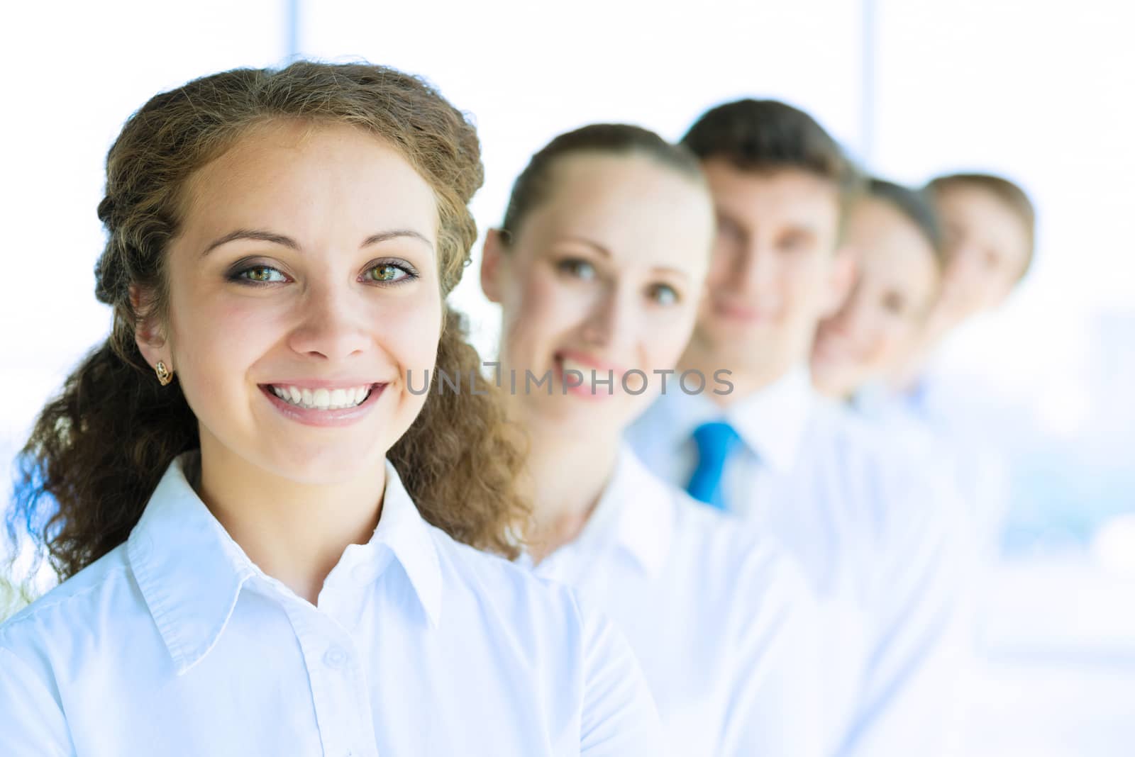 portrait of a young business woman standing in line with colleagues, concept of teamwork