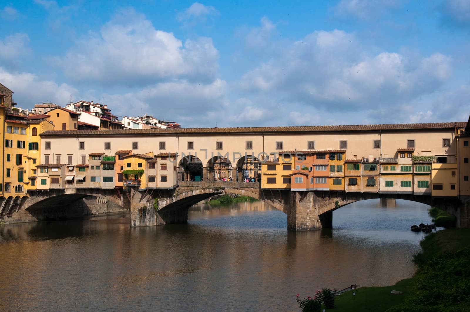 Crowds of tourists visit the Ponte Vecchio ("Old Bridge") which is a Medieval bridge over the Arno River in Florence, Tuscany, Italy.