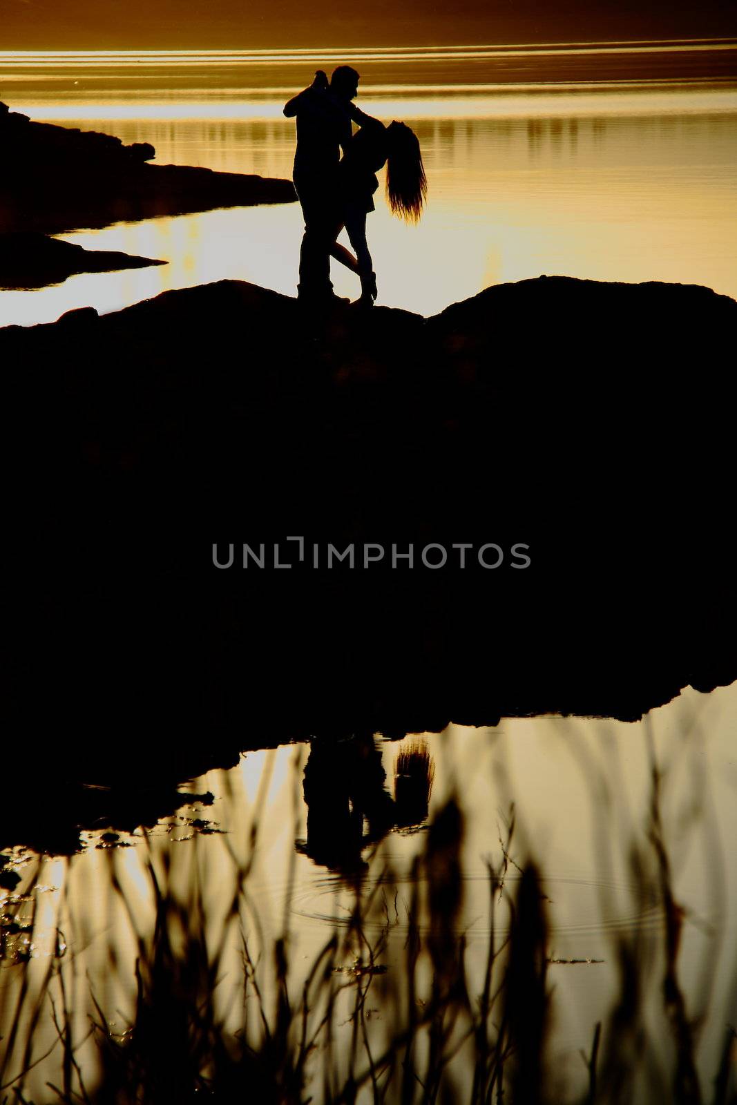 romantic couple dancing near lake at sunset time