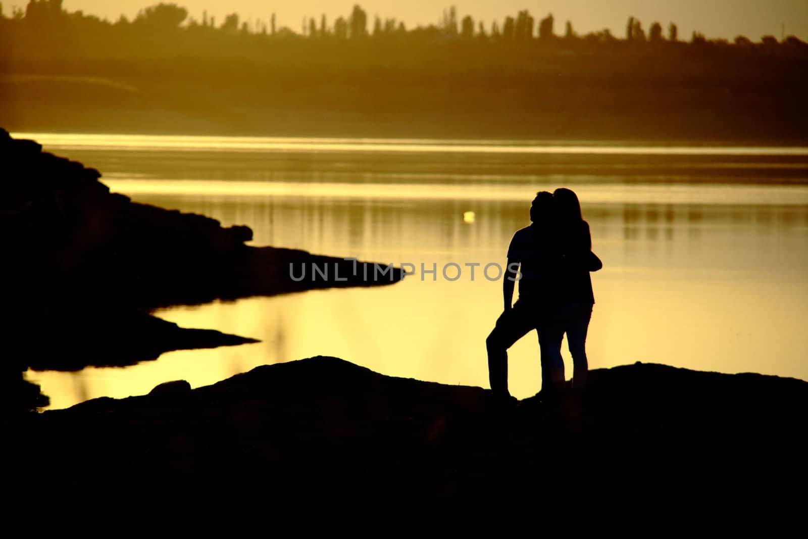 romantic couple watching sunset while standing