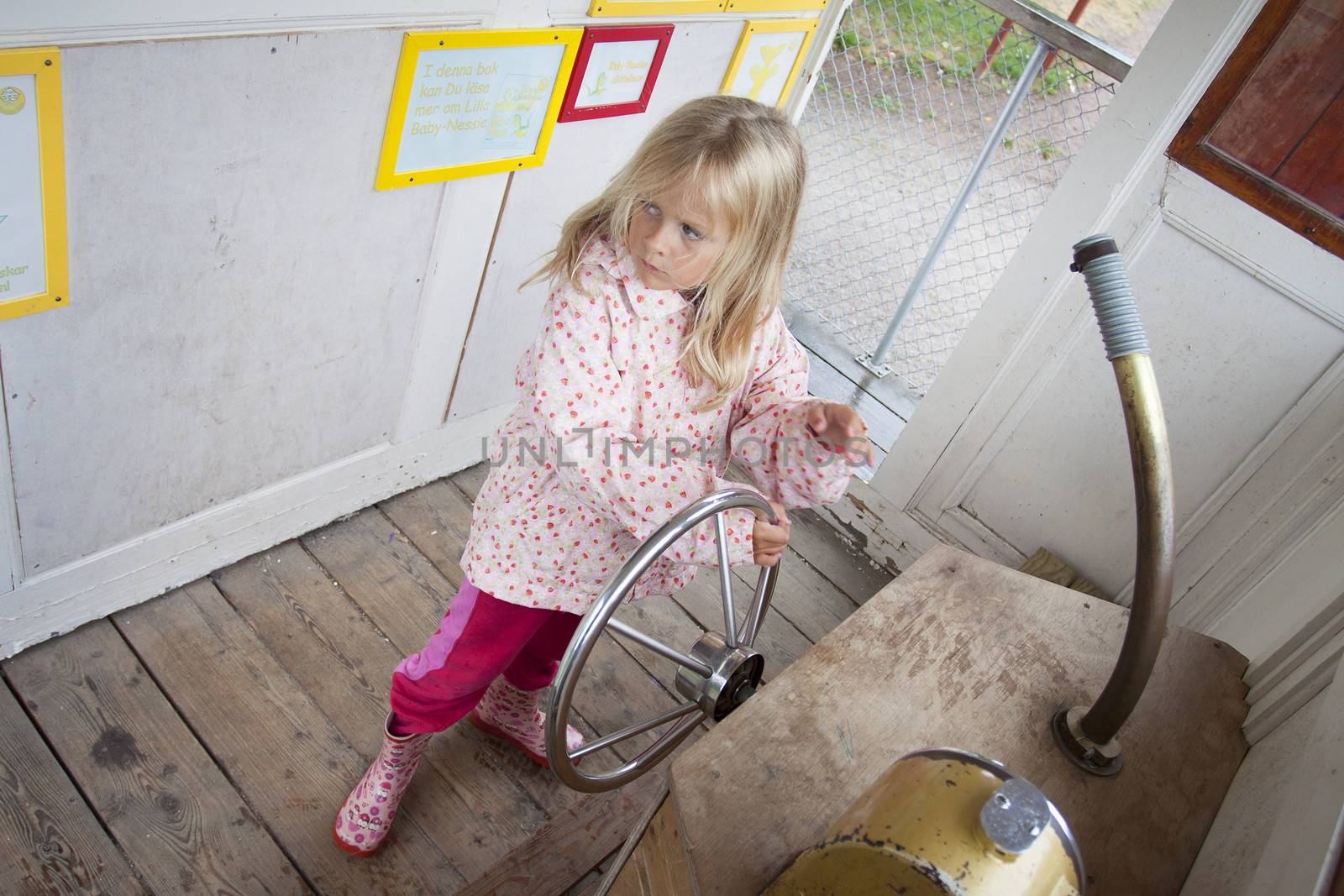 A preschool aged girl inside a wooden ship at Norrkvarn, Göta kanal, sweden, Candid shot real people