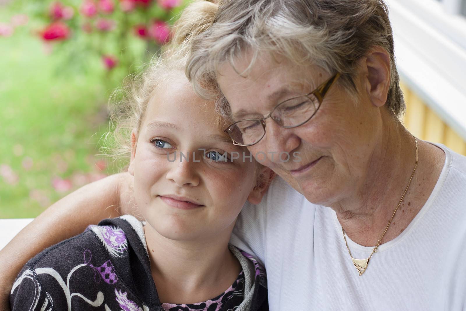 And old woman with eyes closed hugging a young child