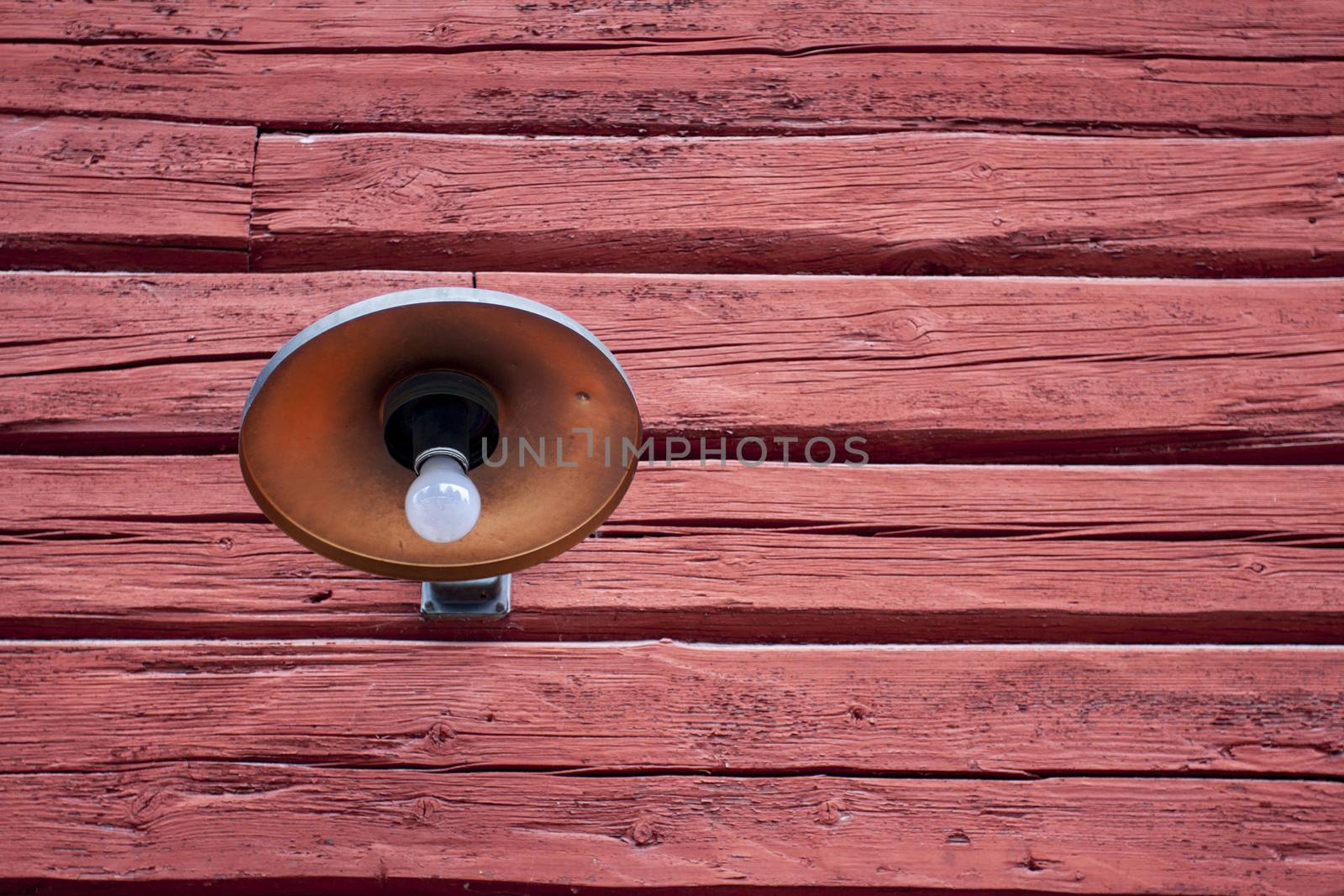 A lamp from early last century on a red barn in Sweden