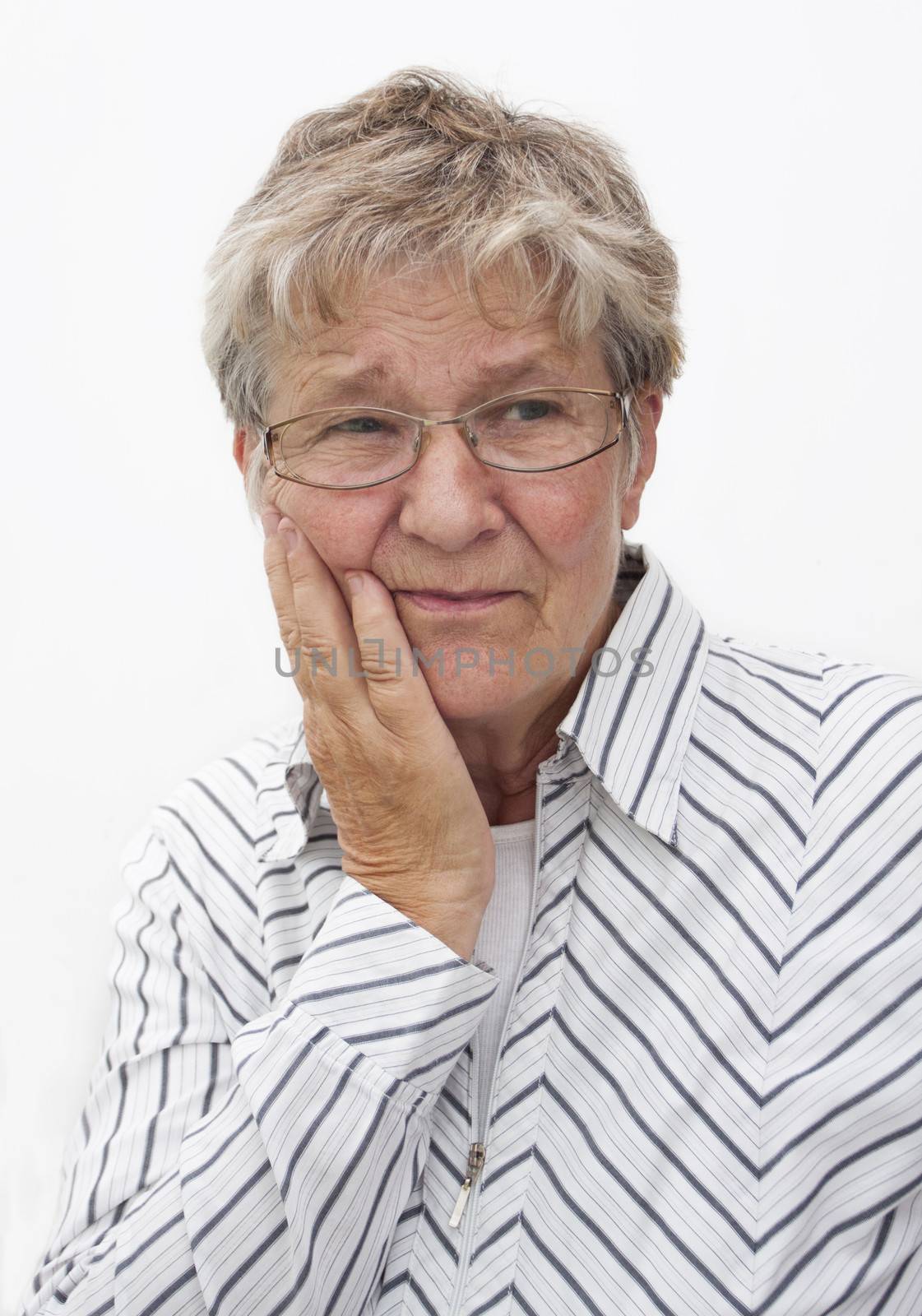 A senior citizen holding a hand to her cheek having pain in teeth