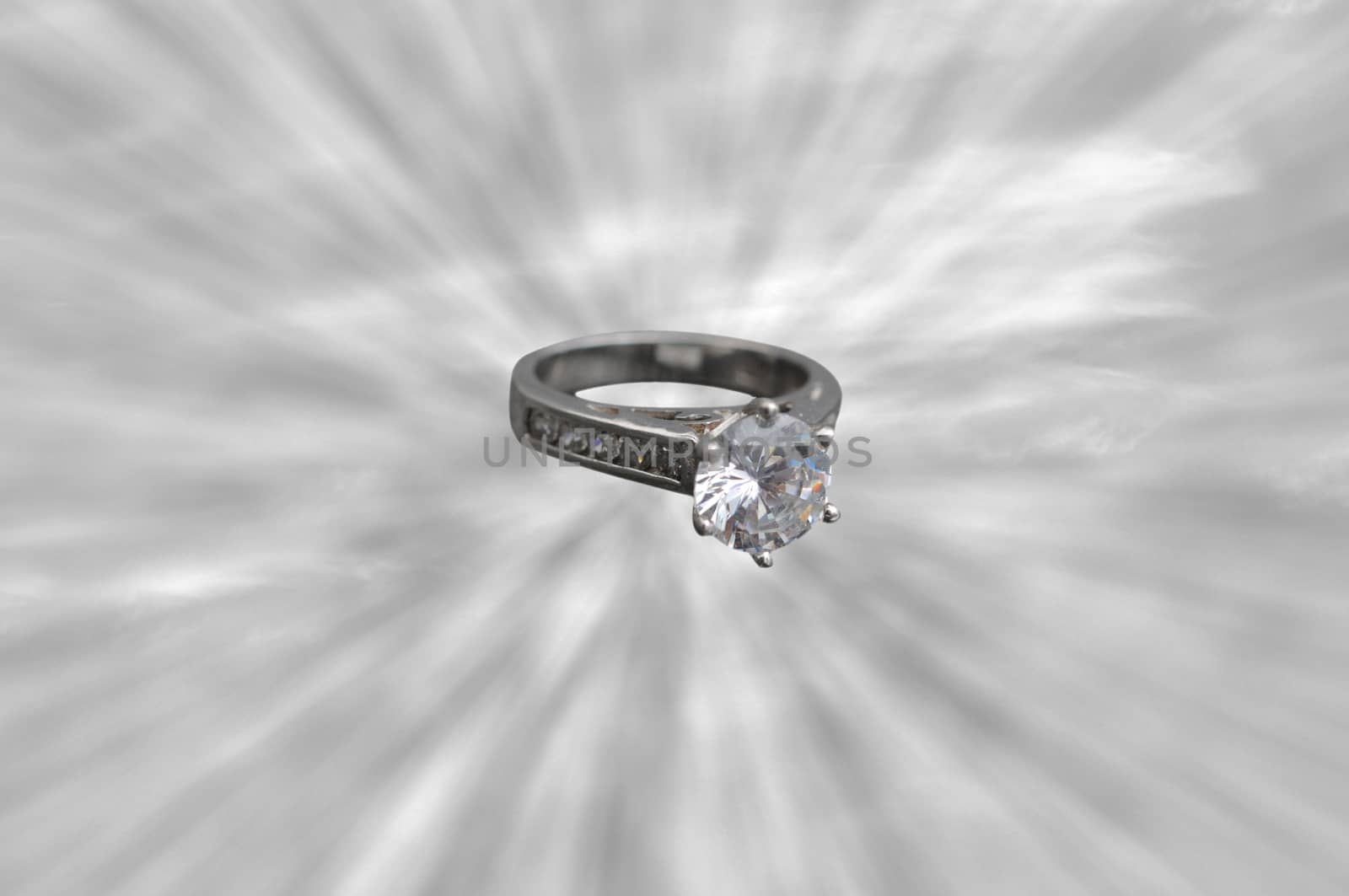 An engagement ring or wedding ring in the middle of a sun rays 