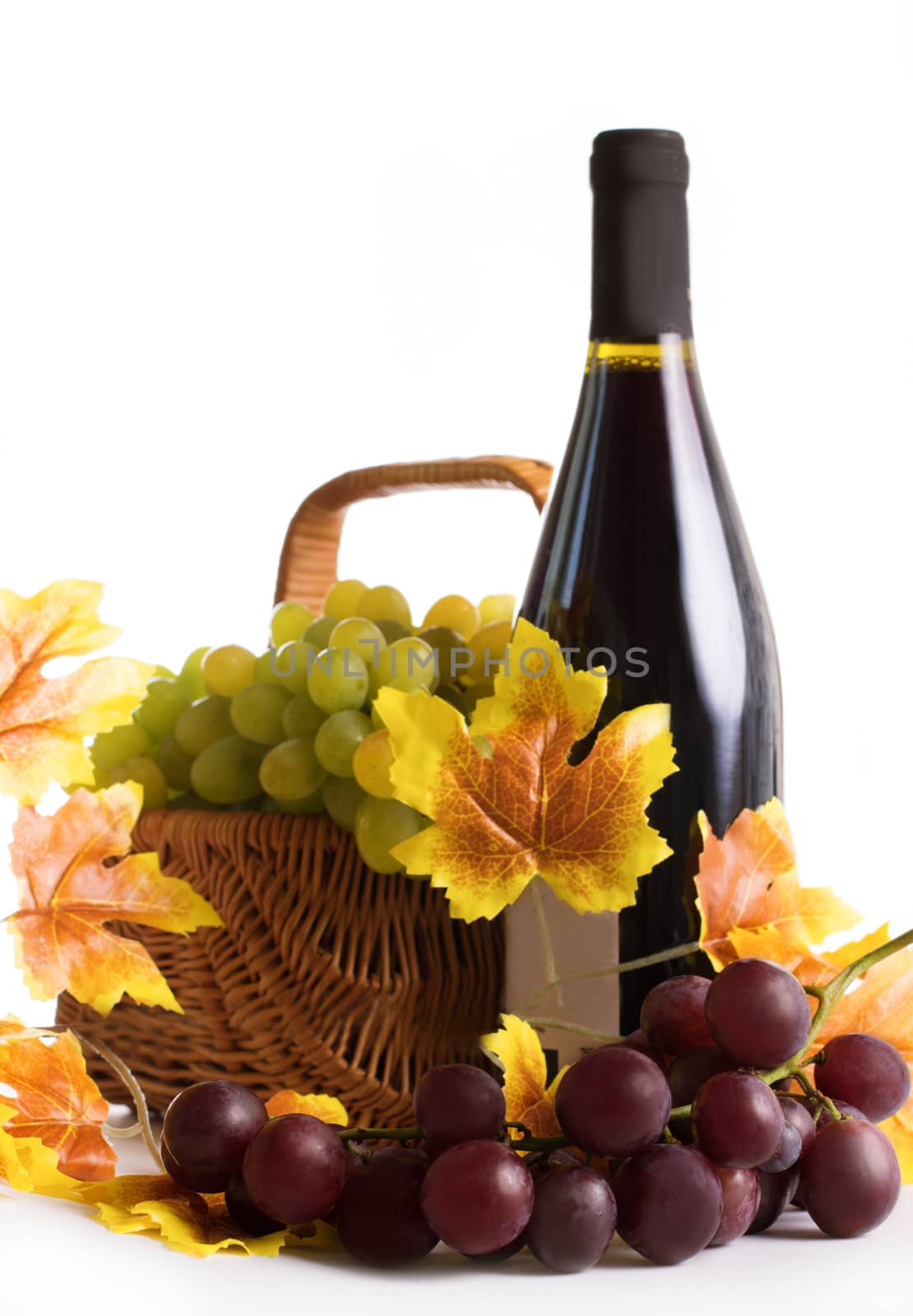 Bottle of wine with grapes in basket isolated on white