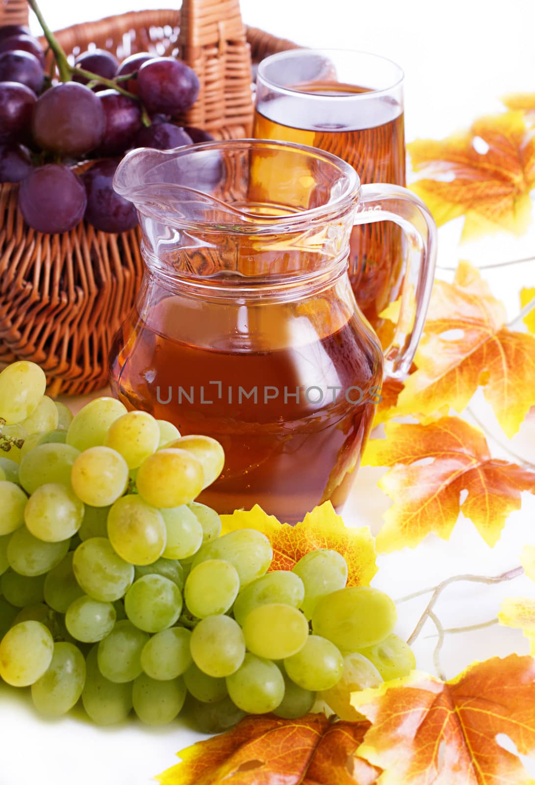 Grape juice in jug and autumn leaves