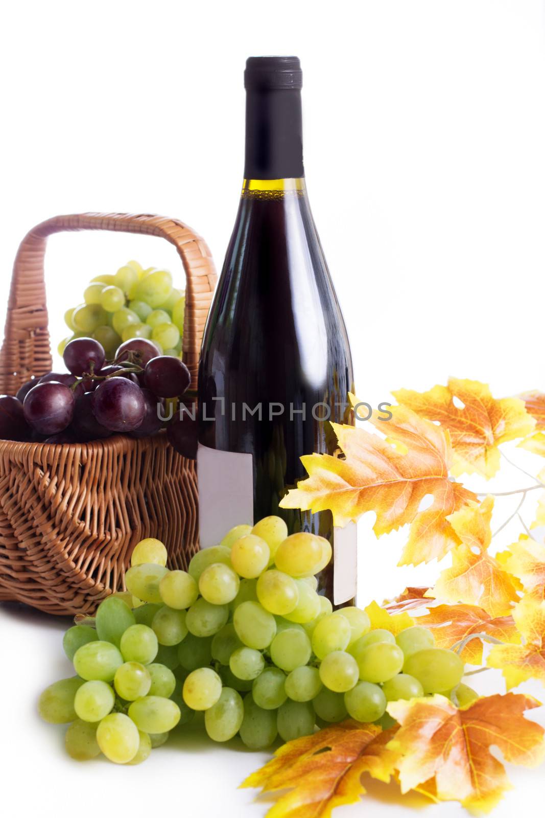 Ripe red and dark grapes and wine in basket isolated on white