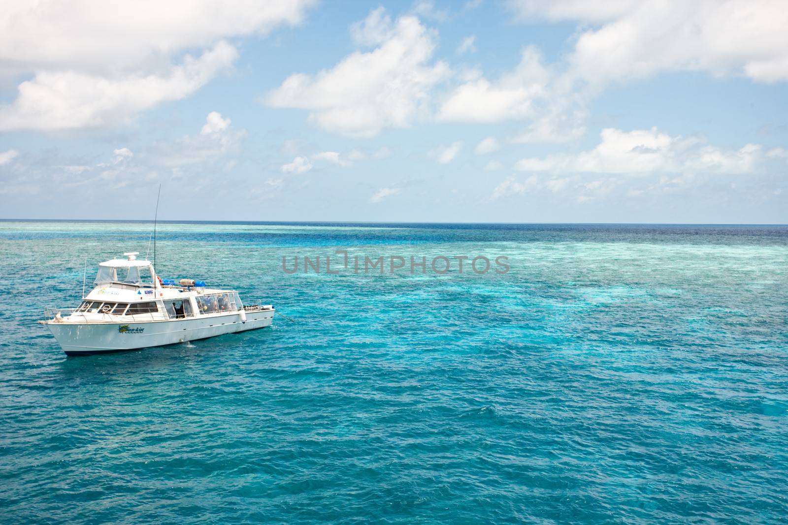 Dive boat stationed off the Great Barrier Reef in Queensland, Australia in a calm blue ocean