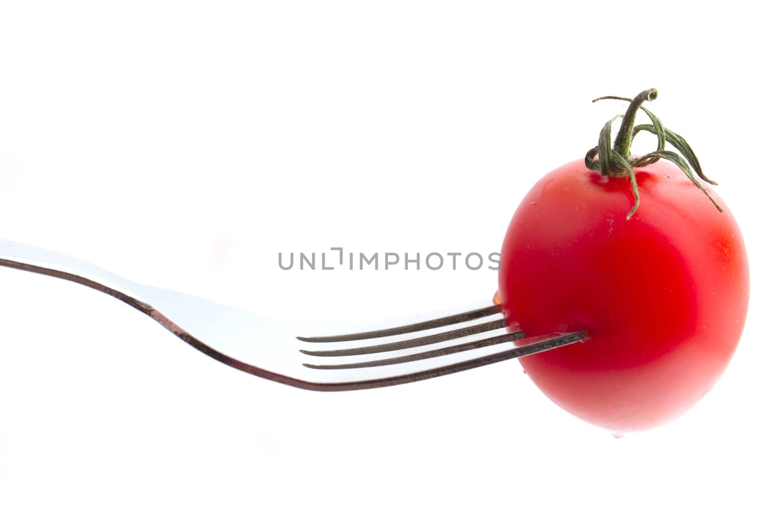 cherry tomato on fork isolated on white