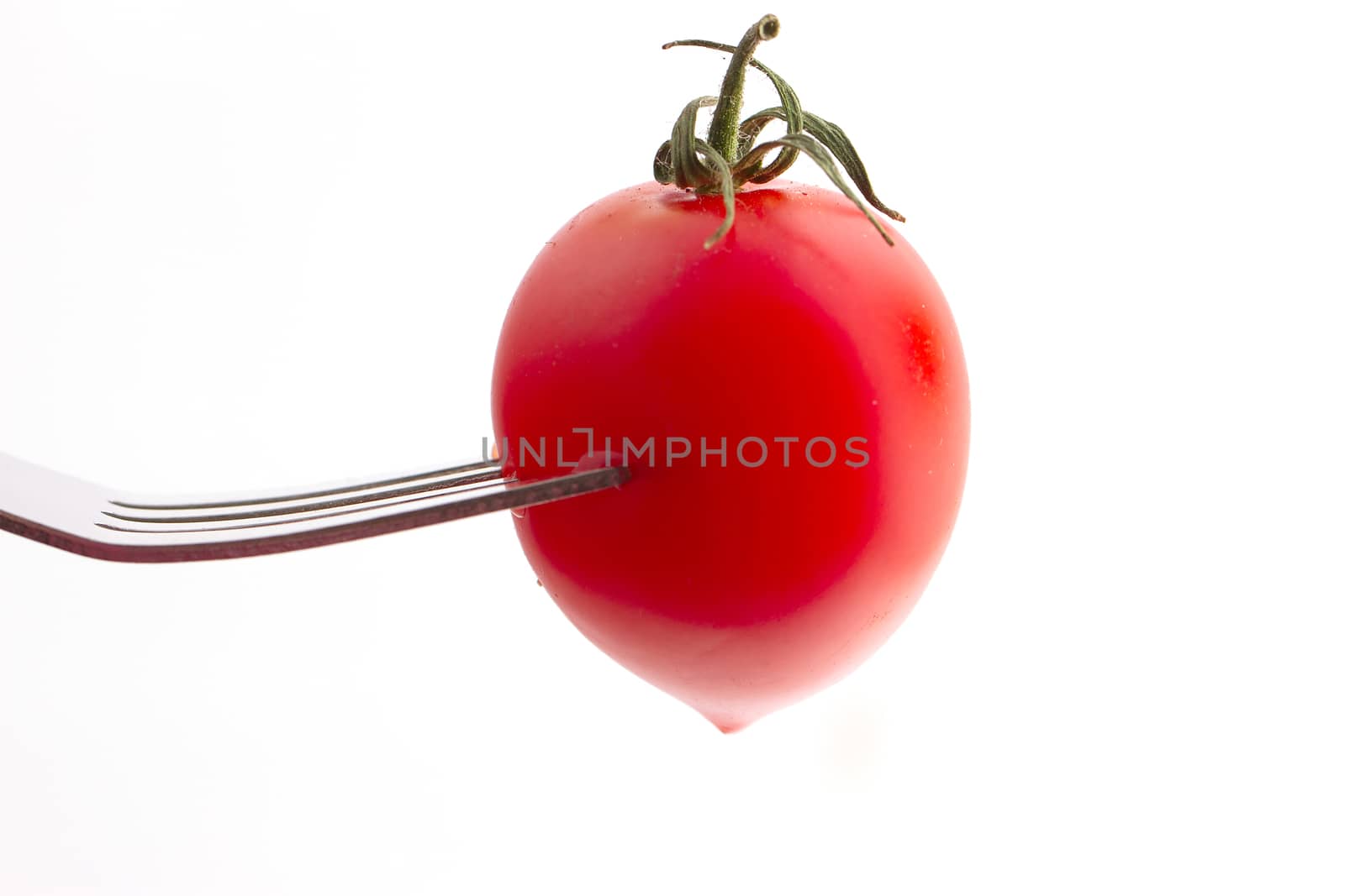 cherry tomato on fork isolated on white