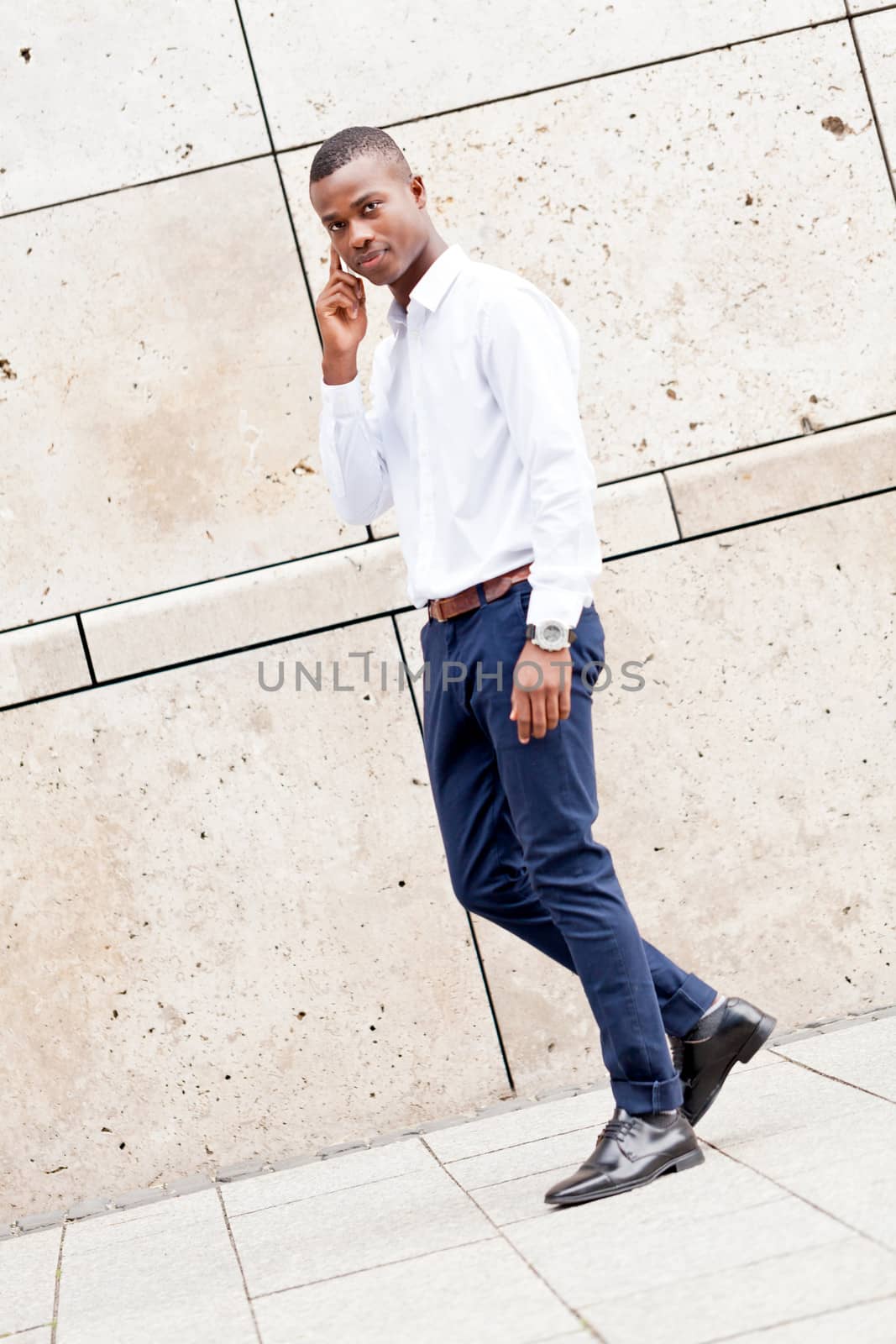 young successfil african businessman with mobilephone talking walking outdoor