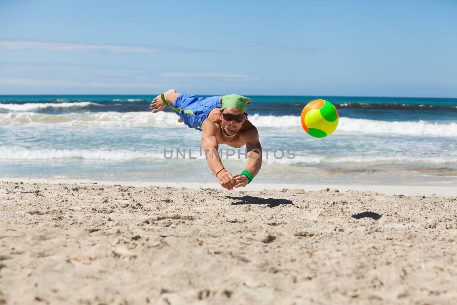 attractive adult man playing beach volleyball in summer holiday vacation