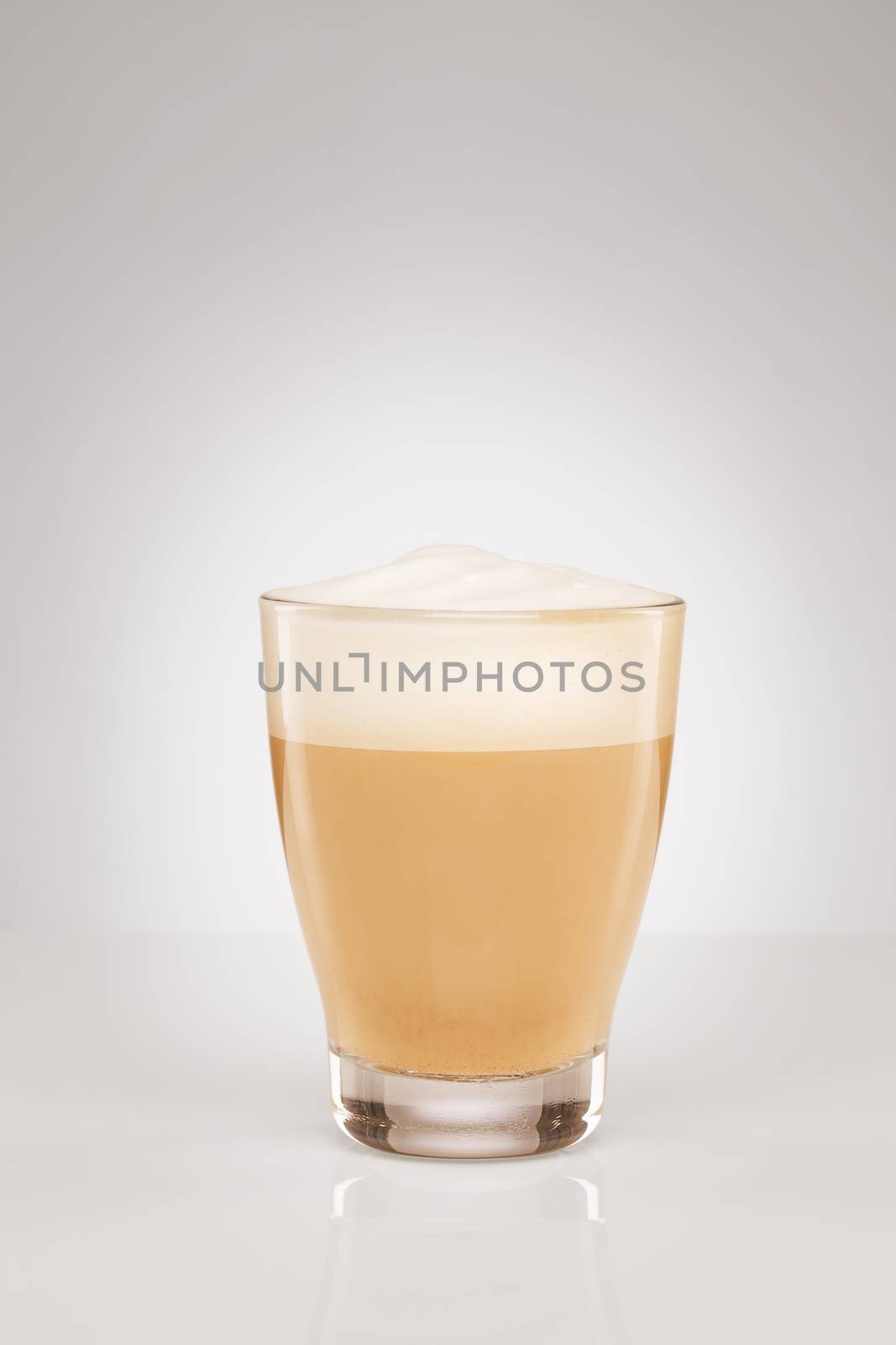 small cappuccino in a glass cup on gray background