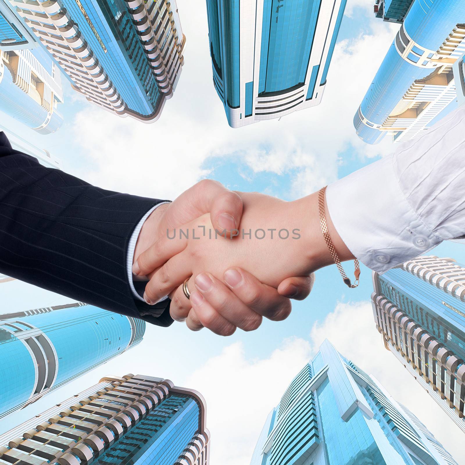 Close up image of hand shake against skyscrapers