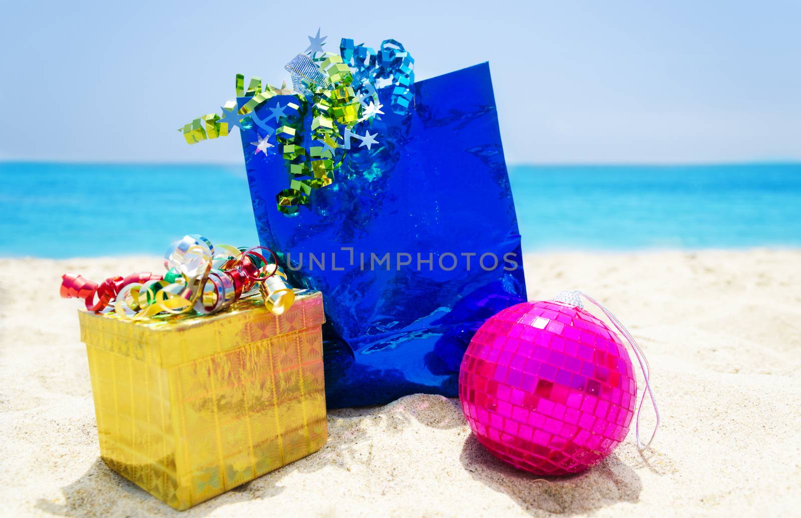 Gifts with Christmas ball on the beach by EllenSmile