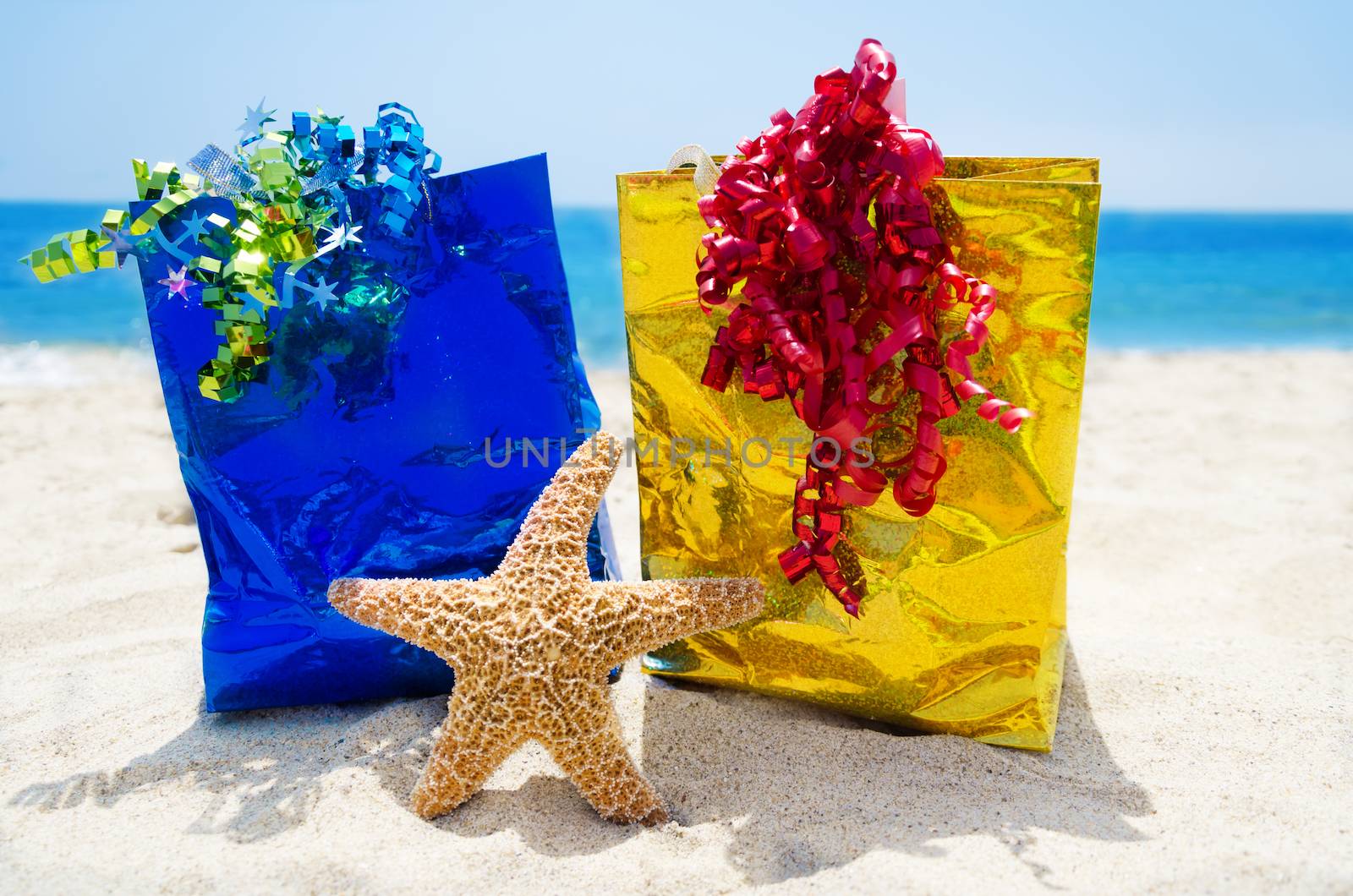 Starfish with gift bags on the beach - holiday concept by EllenSmile