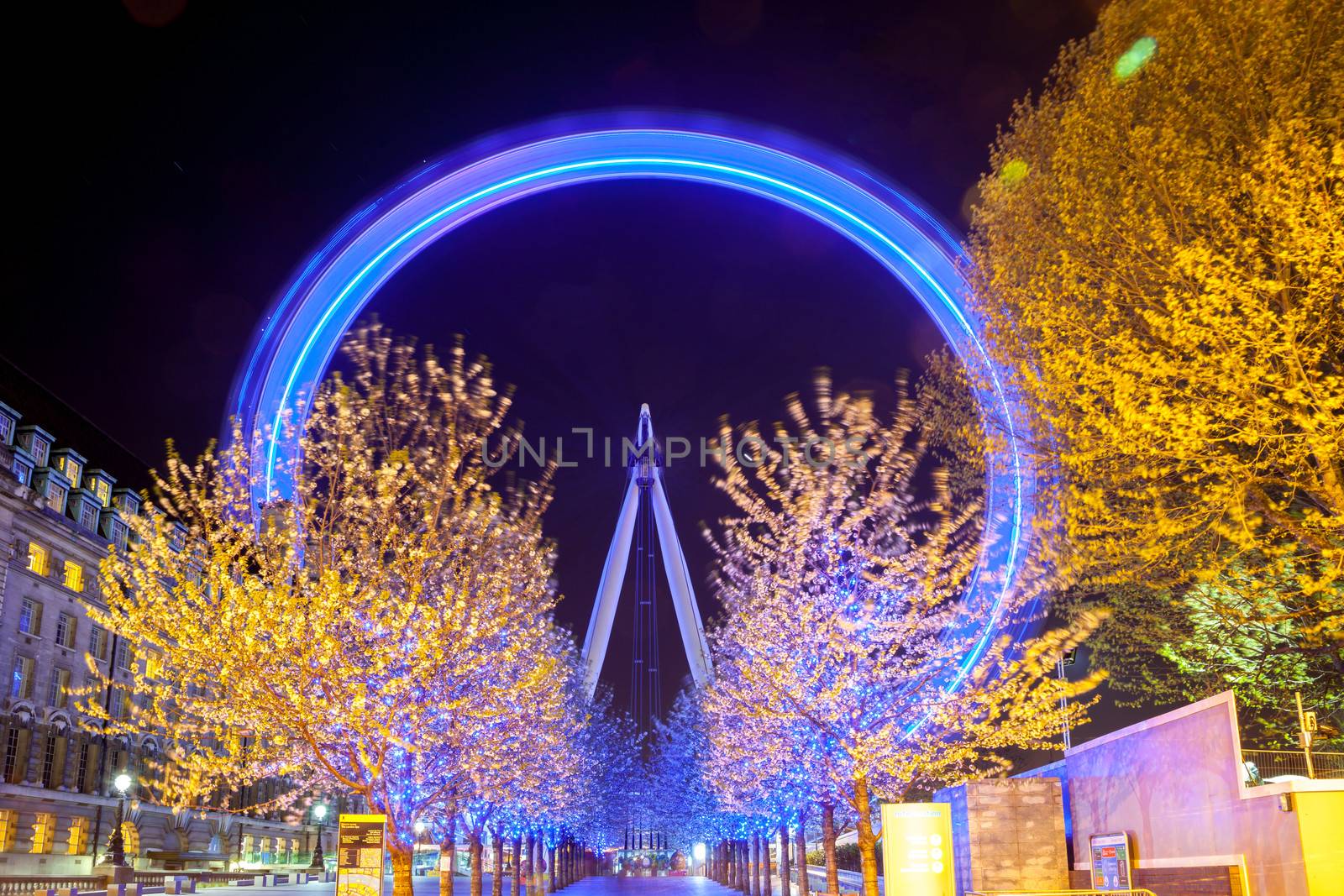 LONDON - April 15: Trees lead to the London Eye, on April 15, 2012 in London. The largest Ferris wheel in Europe, structure of the London Eye is 135 M. tall and the wheel has a diameter of 120 M.