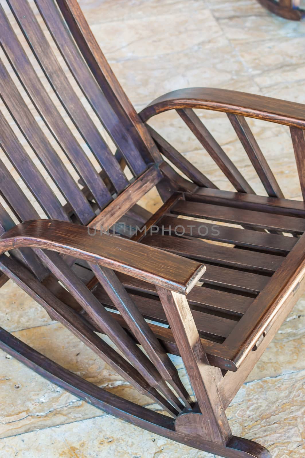 Rocking chair in a room with a marble floor.