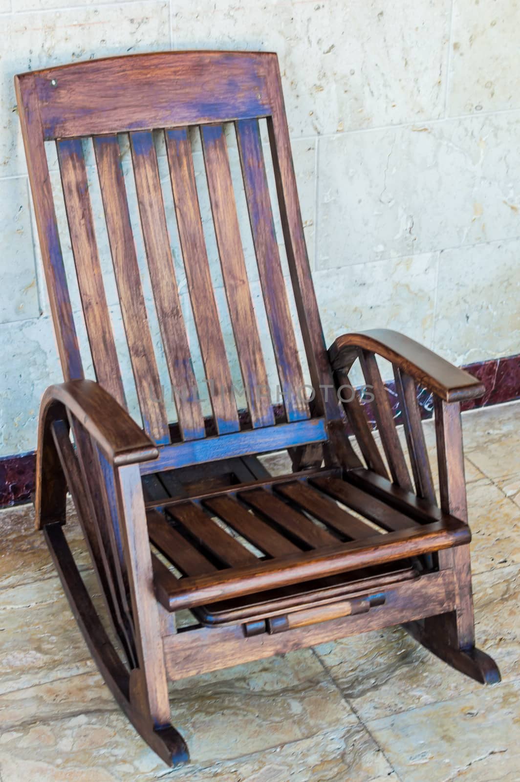 Rocking chair in a room with a marble floor.