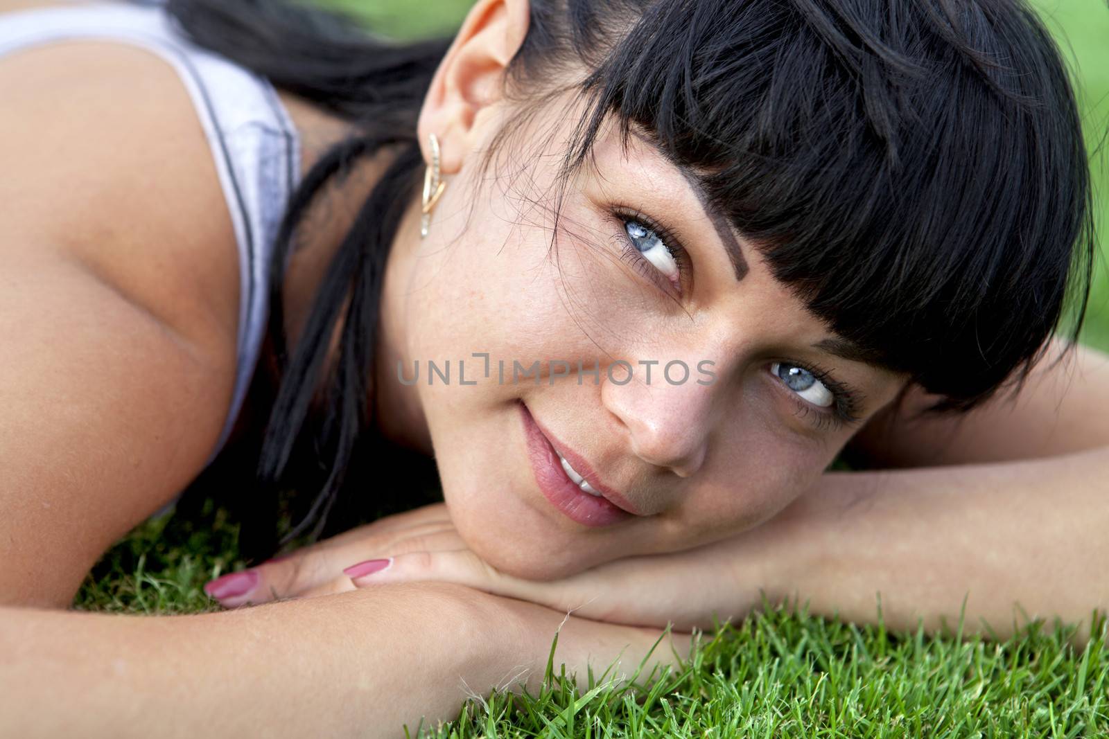woman lies on grass by ssuaphoto