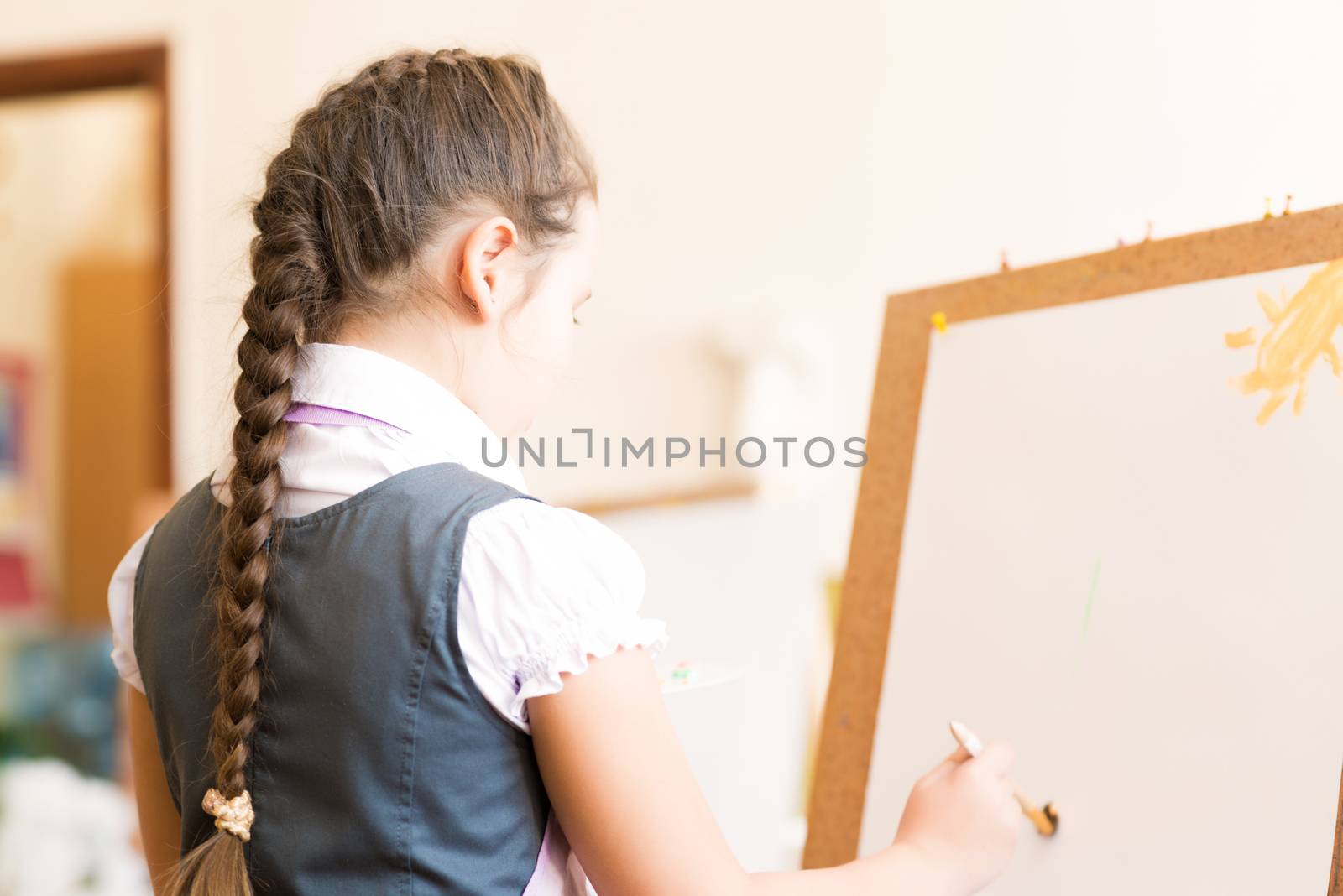 girl in apron interested in painting at an art school