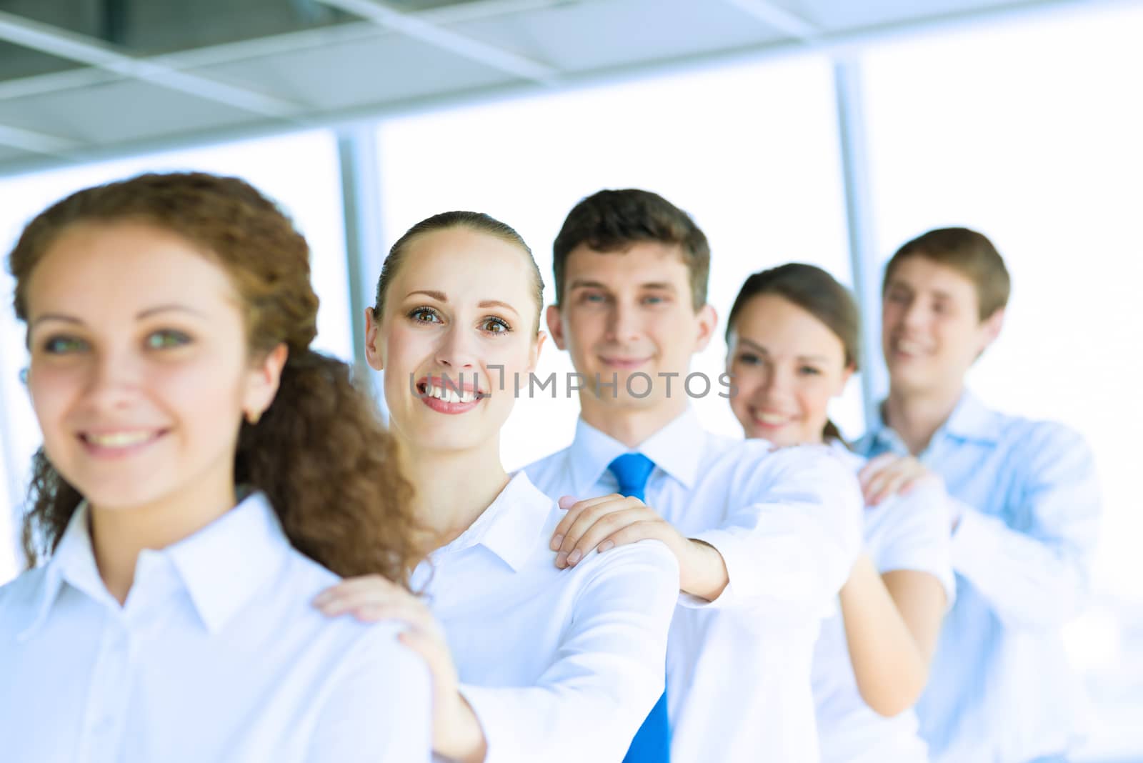 portrait of a young business woman standing in line with colleagues, concept of teamwork