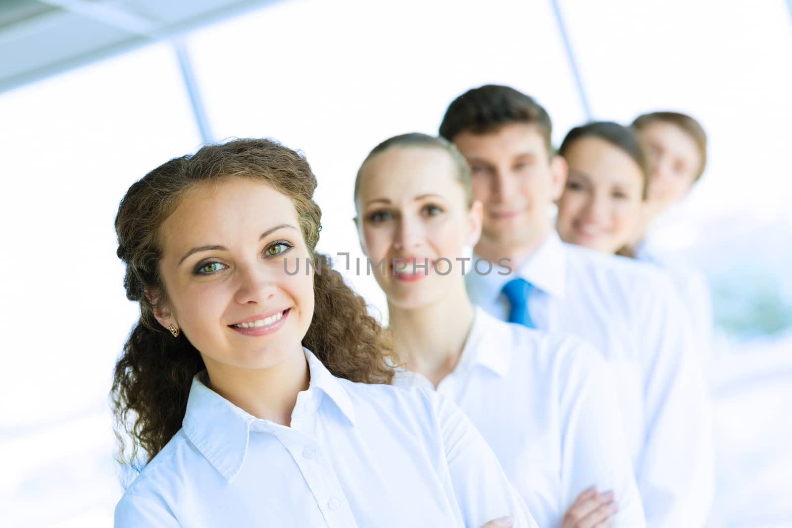 portrait of a young business woman standing in line with colleagues, concept of teamwork