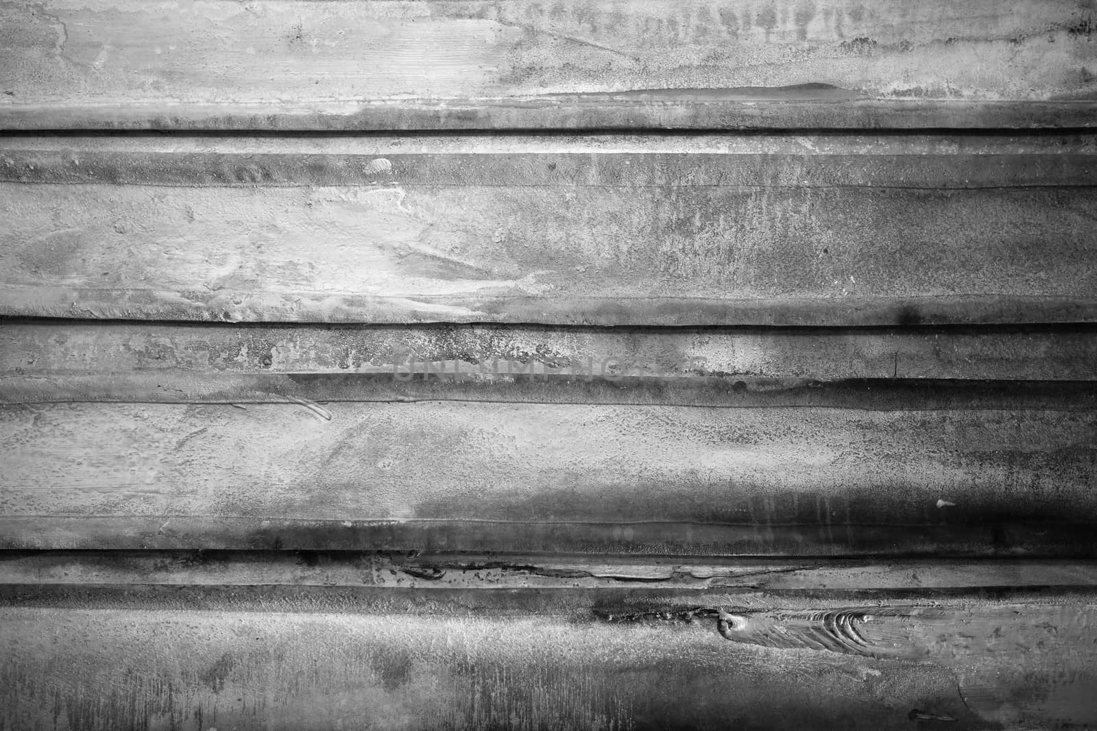 Black and white photo of a weathered textured surface.