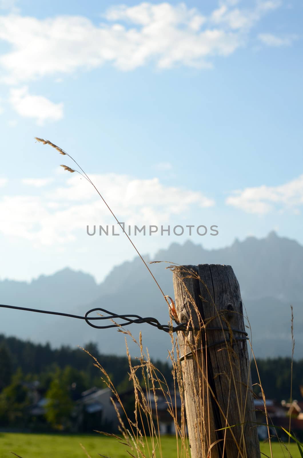 Scenic Mountain Scene With Fence And Grass In The Foreground