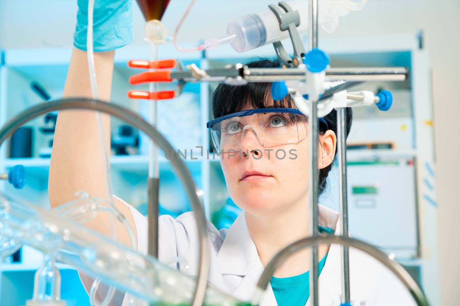 Scientific researcher holding at a liquid solution in a lab by motorolka