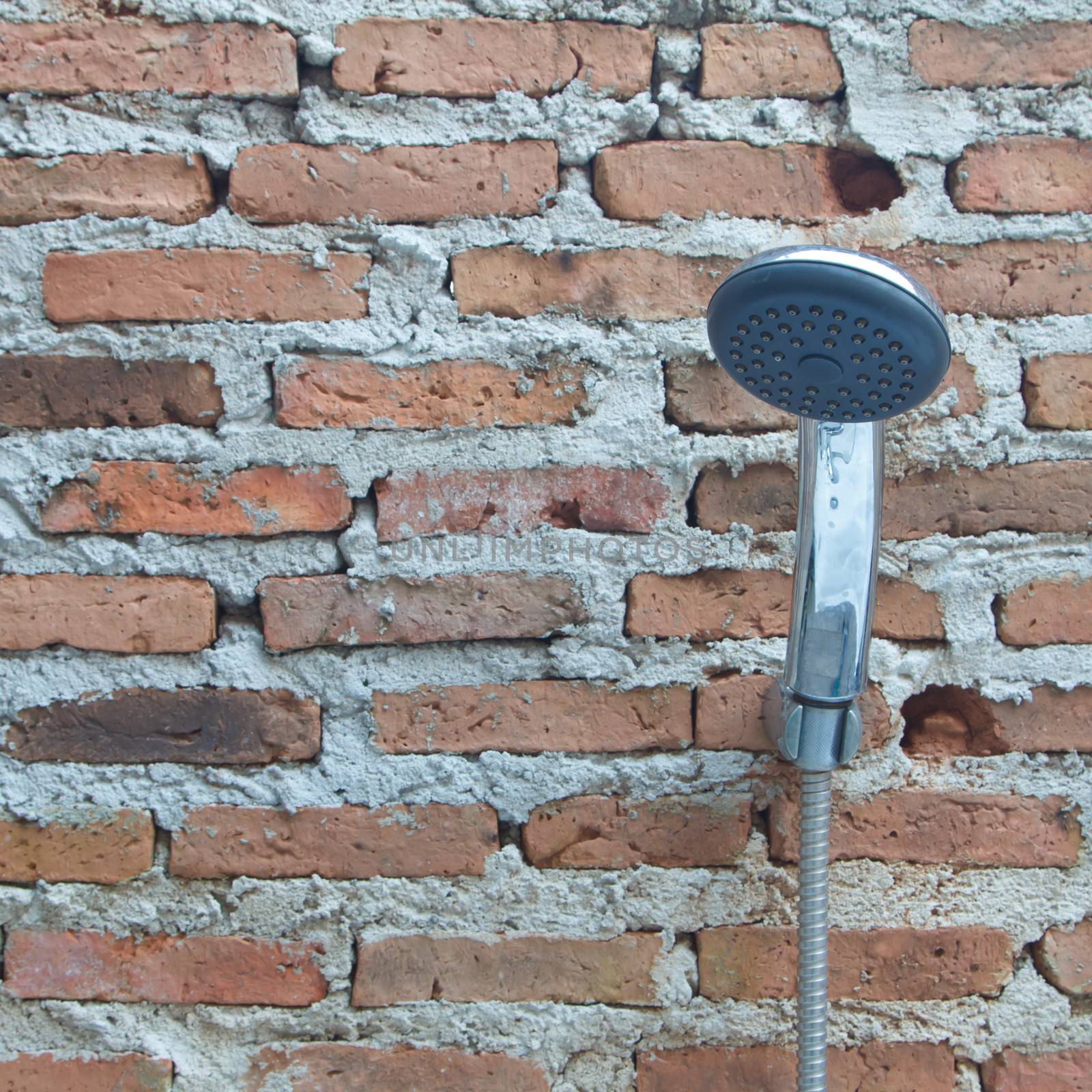 Shower on the old brick wall