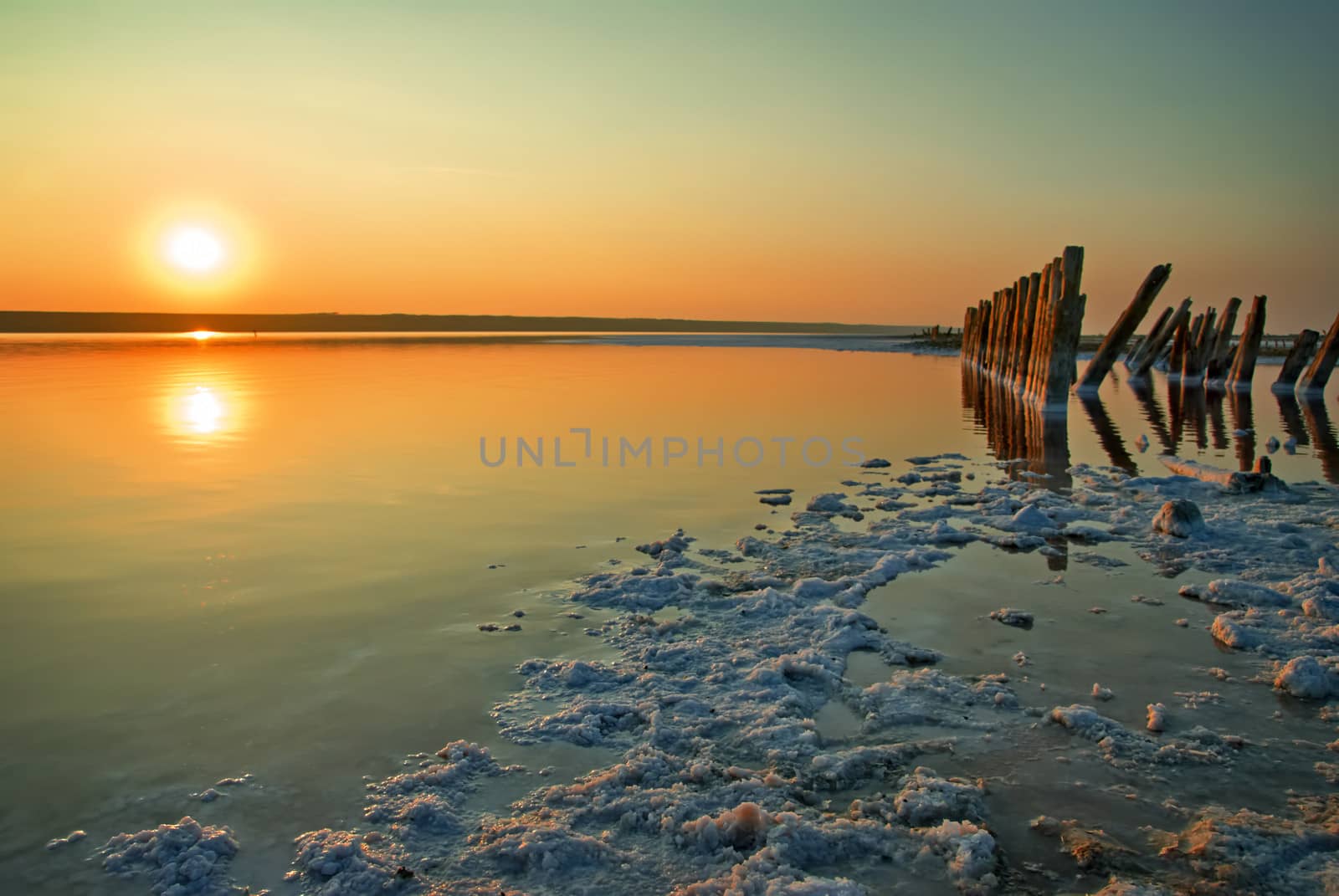 Sunset over the salt lake. All objects in this lake covered with salt. by Zhukow