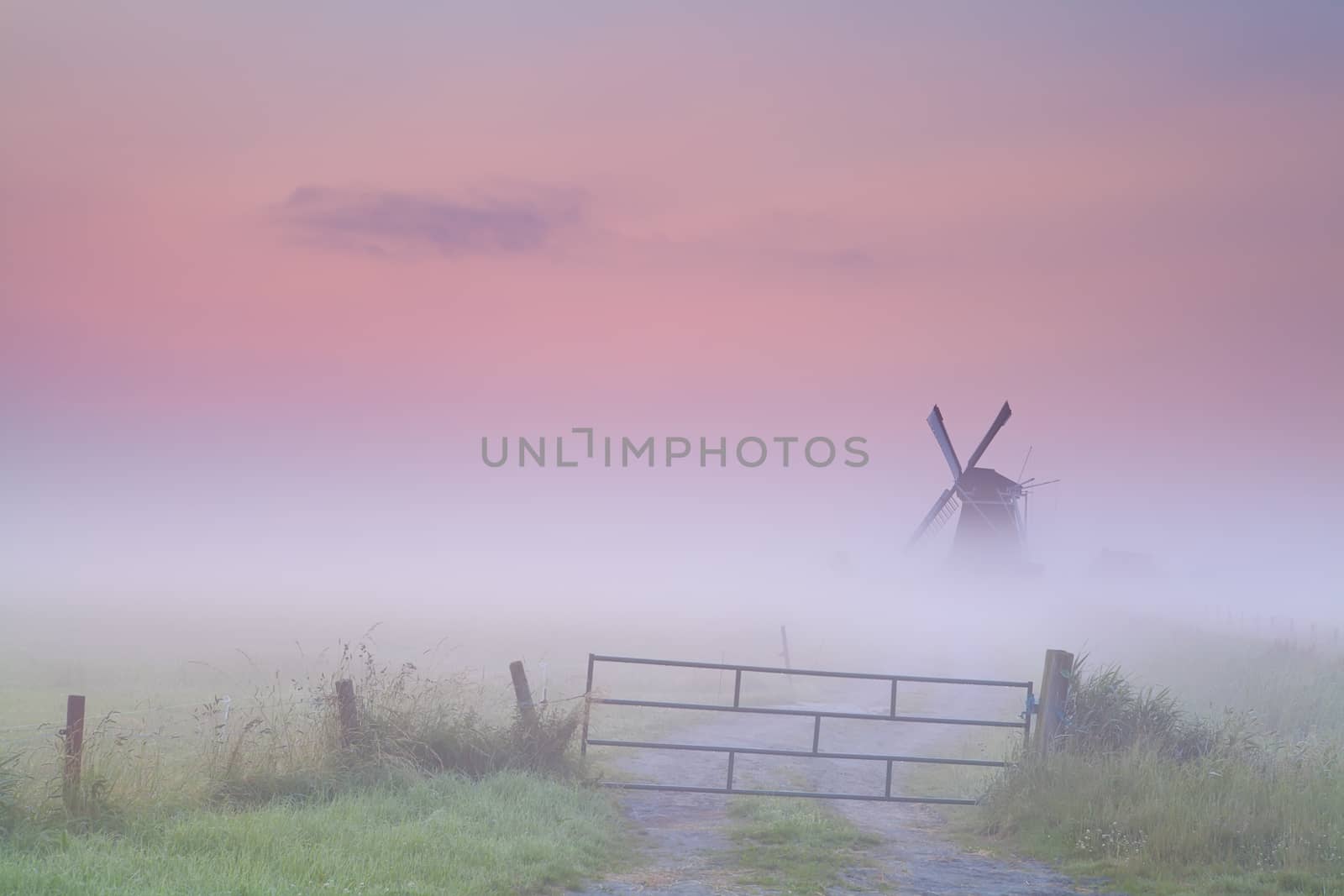 Dutch windmill in dense fog at sunrise, Groningen, Netherlands