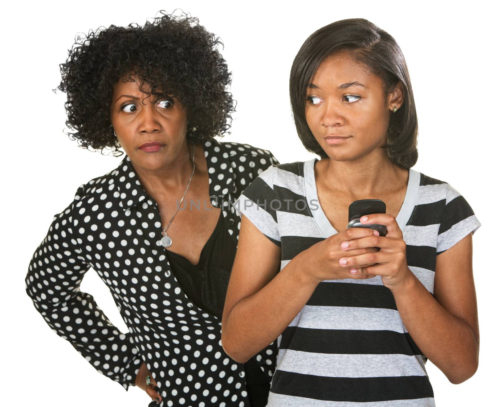 Teenager sneaking cell phone as suspicious mother looks