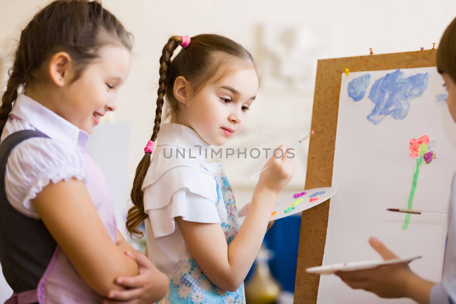 Little children painting and playing at kindergarten