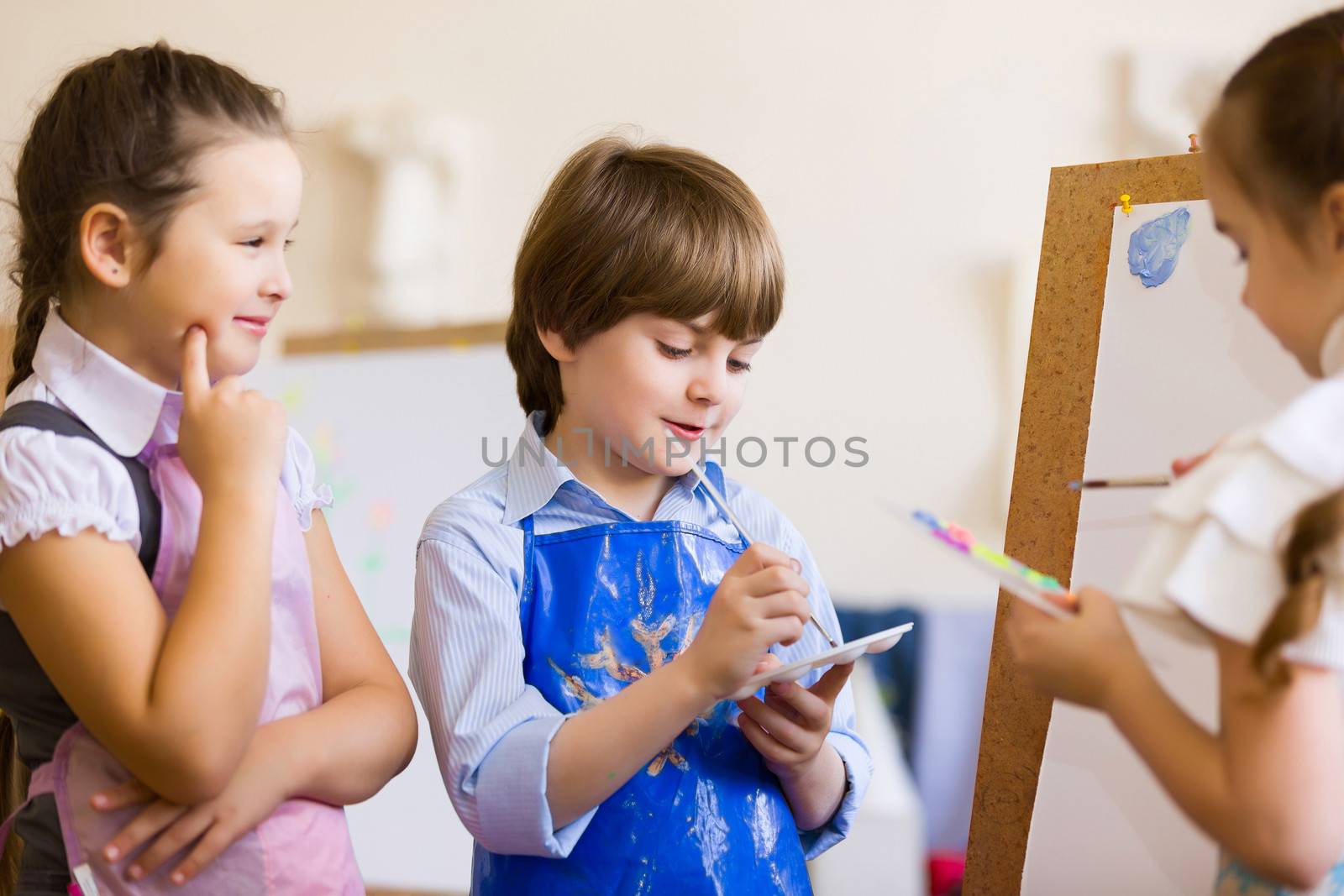 Little children painting and playing at kindergarten