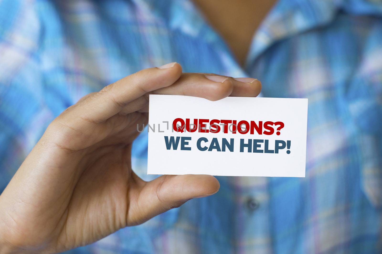 A person holding a white card with the words Questions we can help