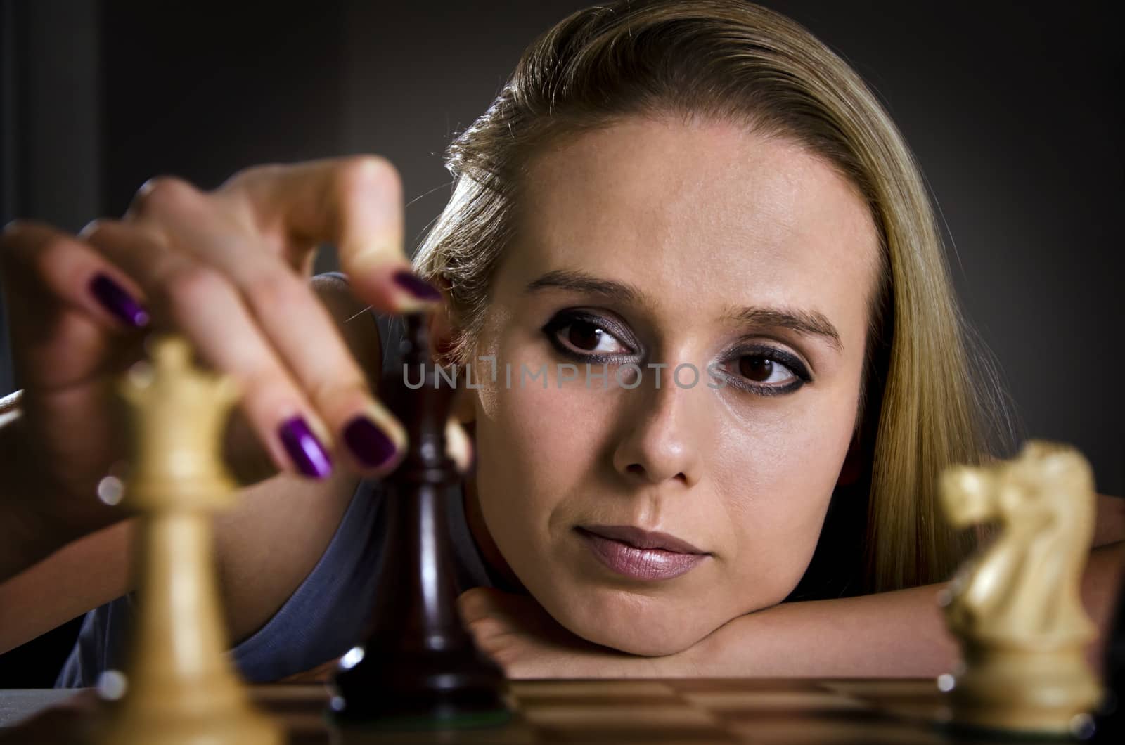 woman playing chess making her move with focus on the eyes of a woman