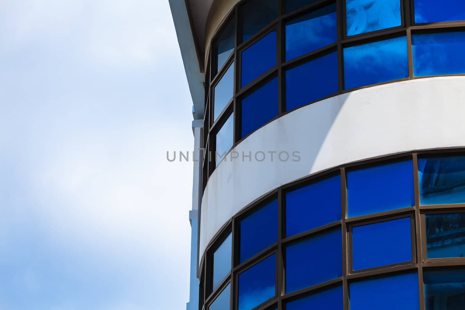 blue sky reflected in modern building mirror glass wall by thanomphong