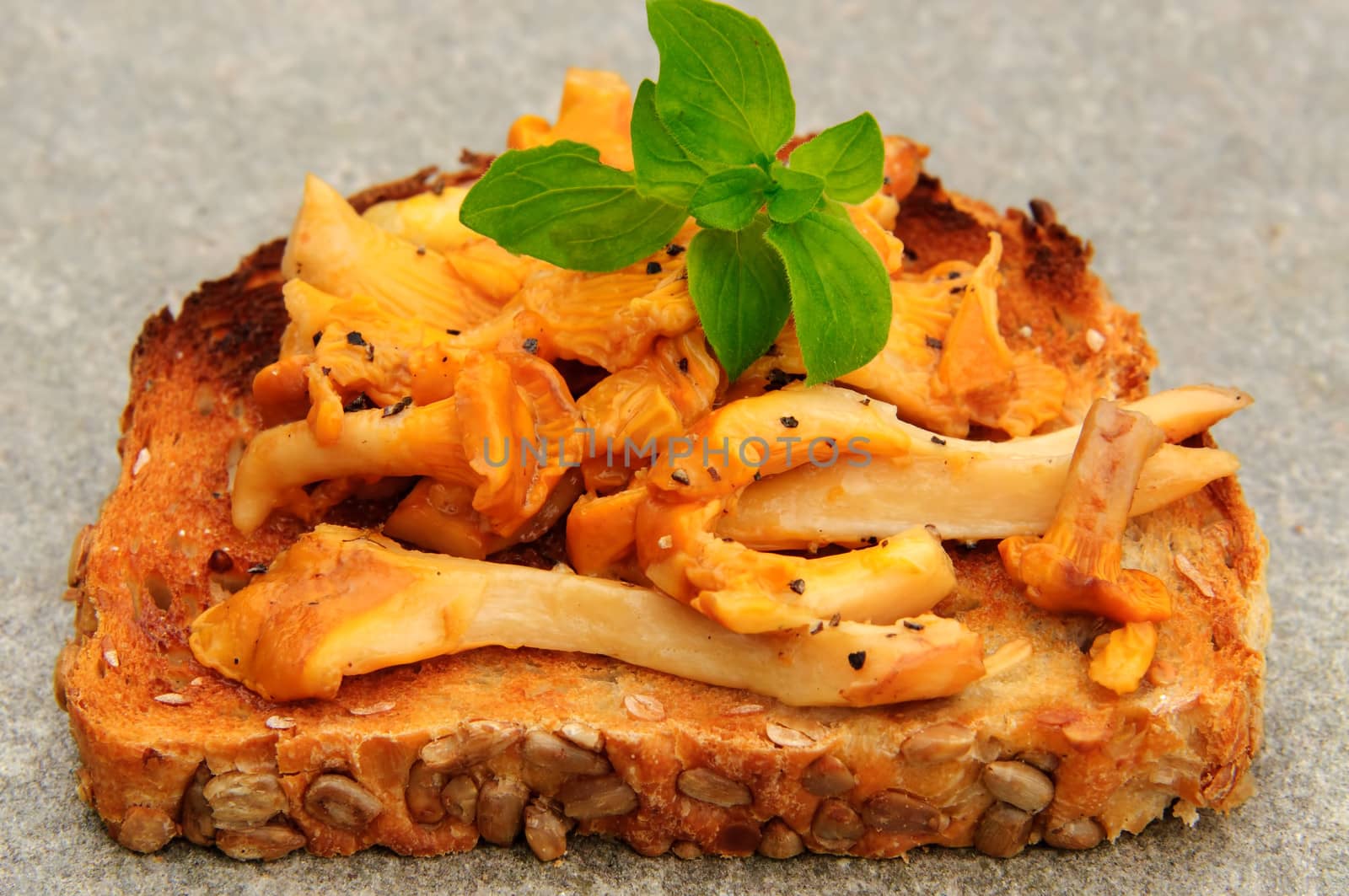 Chanterelles fryed in butter on toast.  Ground pepper and salt is sprinkled over