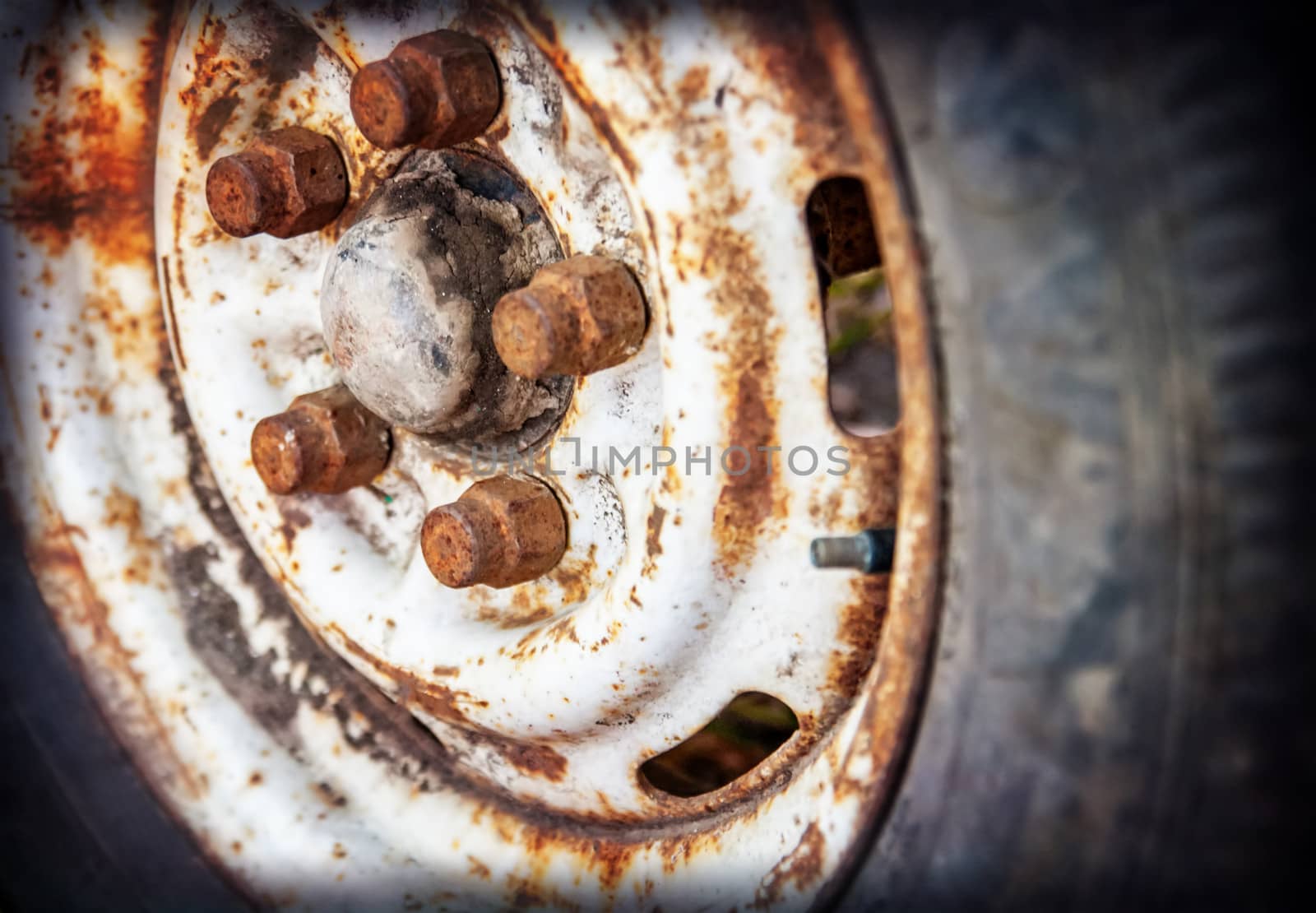 Detail old car wheel with rusty bolts