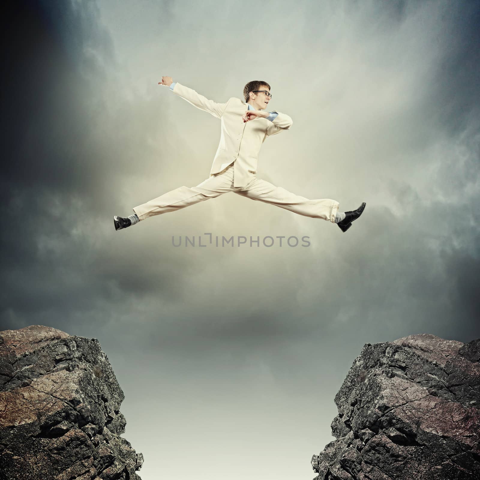 Image of young businessman jumping over gap